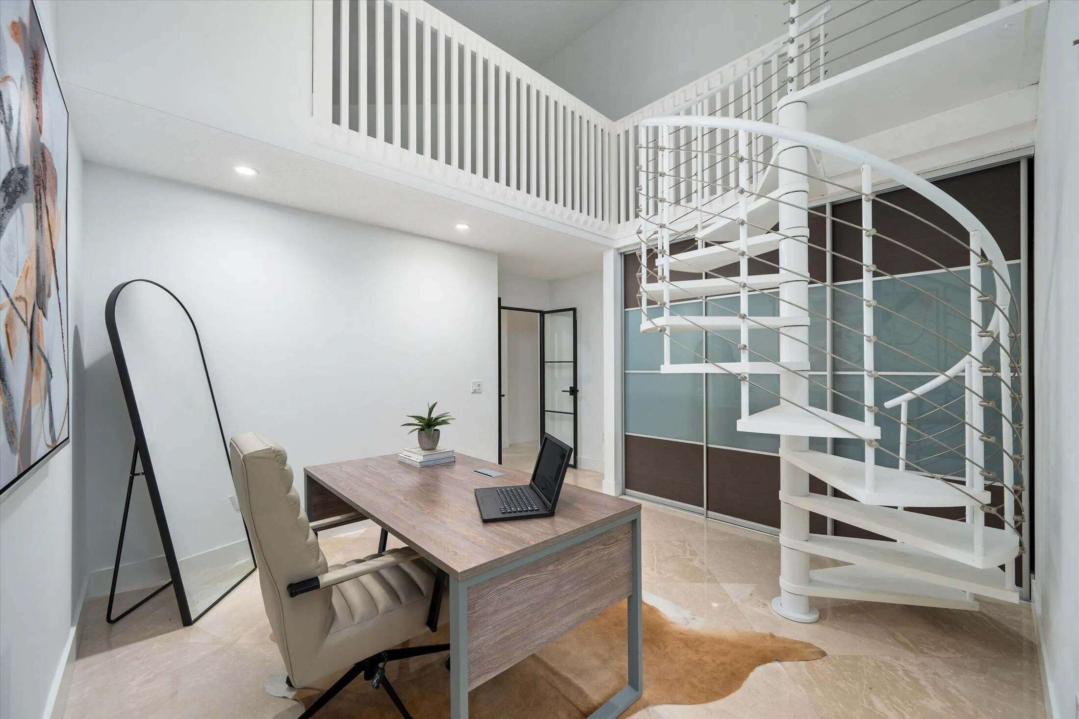 White spiral staircase with cable railings, offering access to a loft space with a white slatted railing