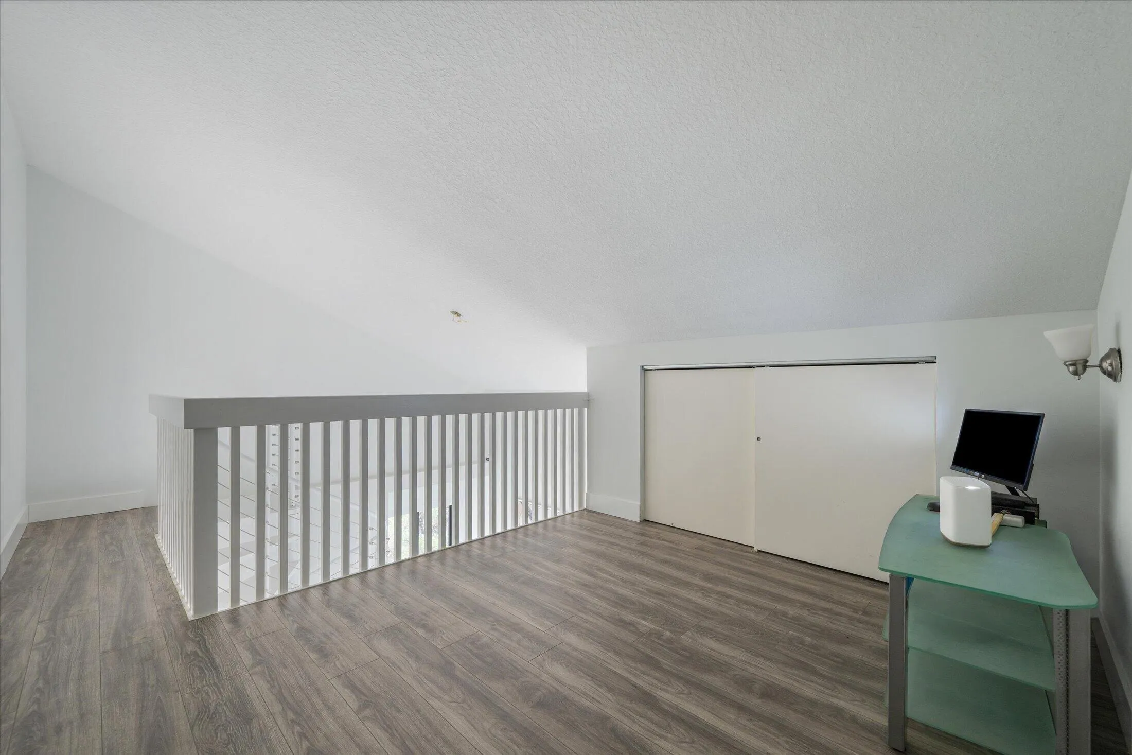 Wood-finish flooring with a white railing