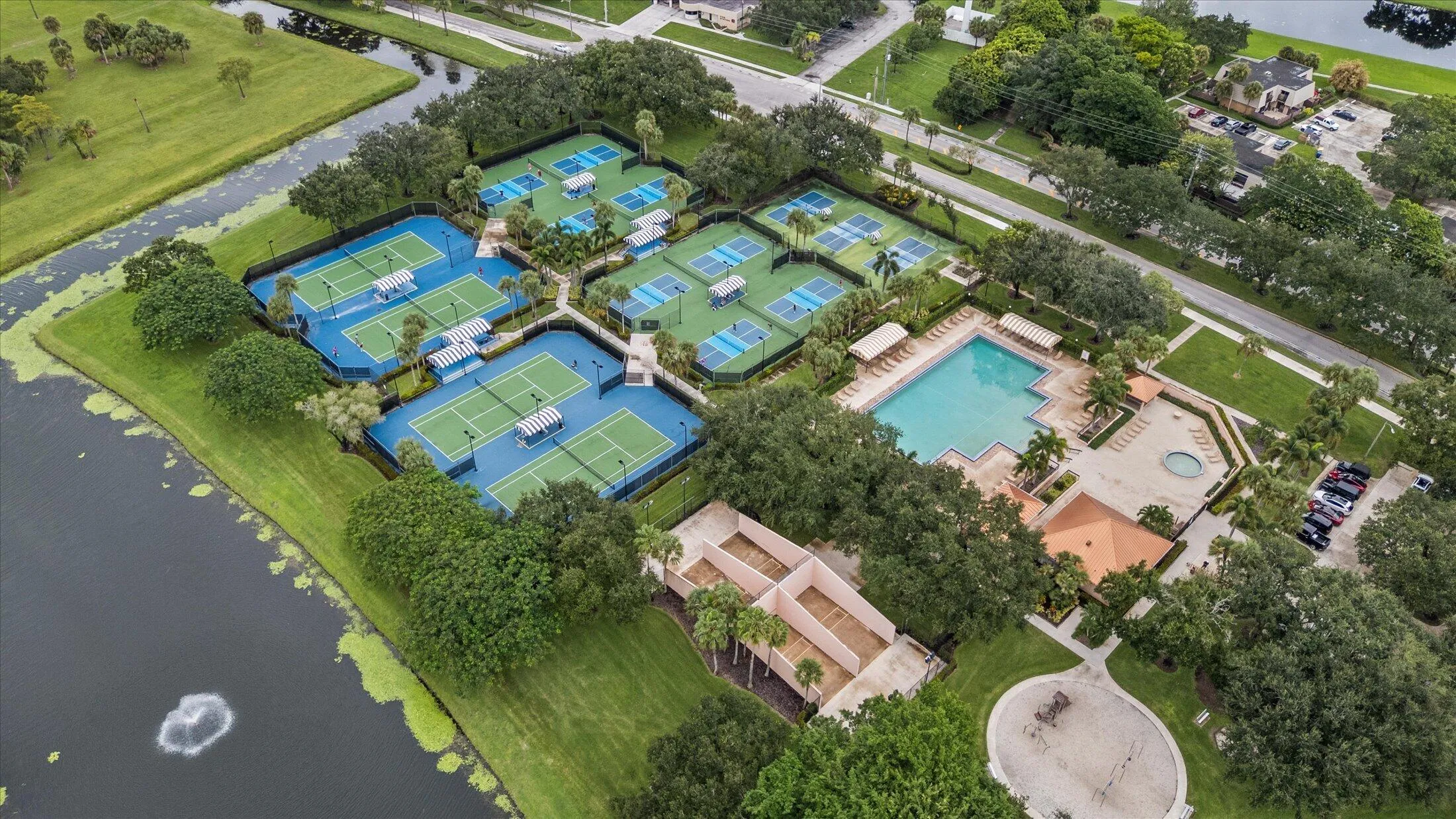 Multiple tennis courts, a swimming pool, and a spa with surrounding hardscaping