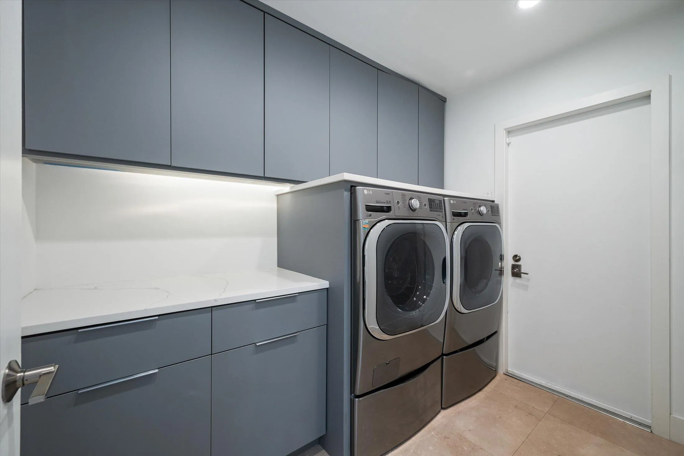 Built-in cabinetry with ample storage, integrated under-cabinet lighting, and a white countertop