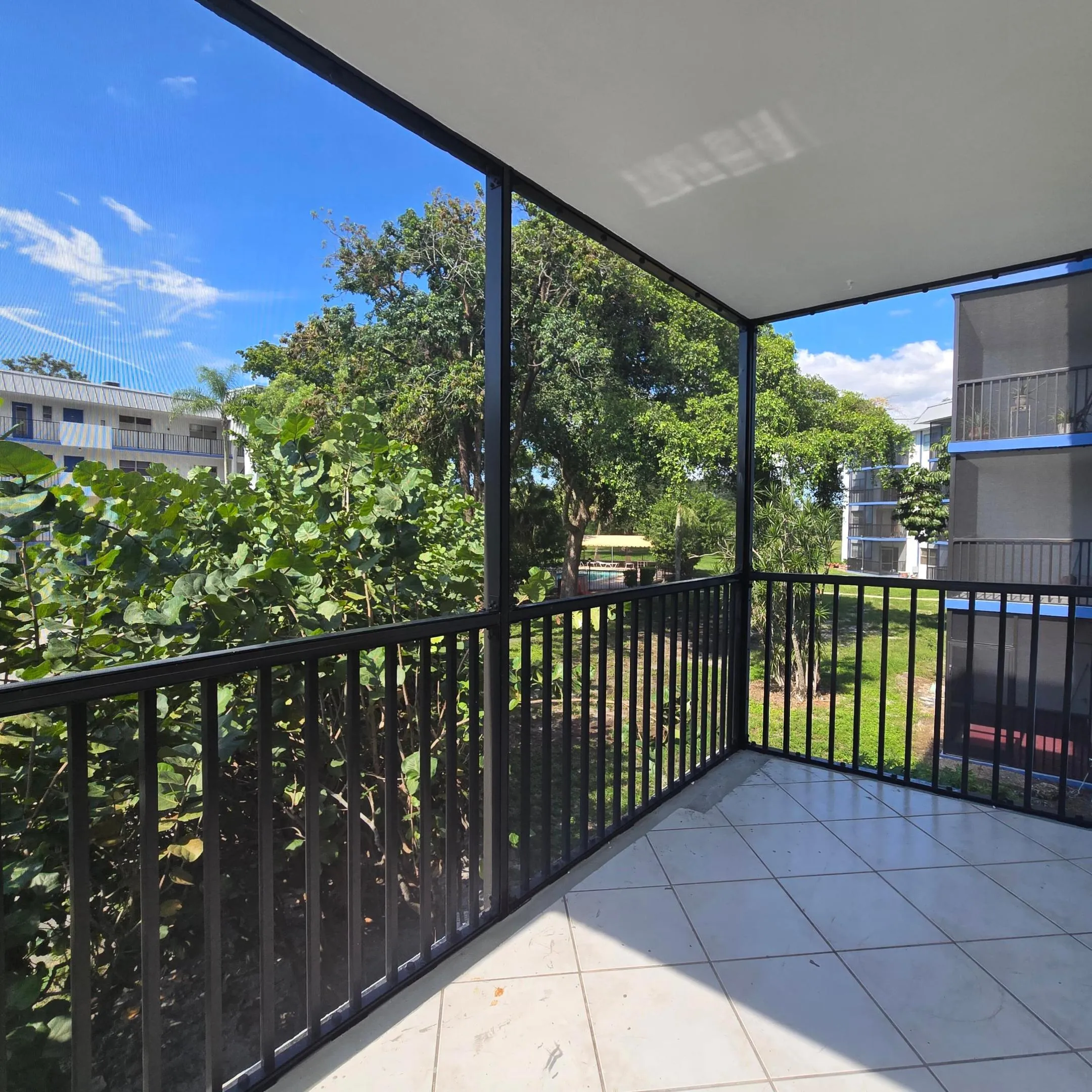 Screened and covered patio with tile flooring.