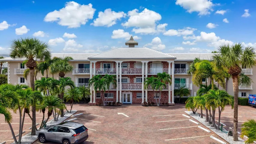 Multi-story building featuring balconies, brick facade, and a cupola