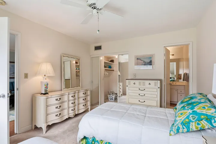 Recessed closet with built-in shelving, ceiling fan, and carpeted flooring