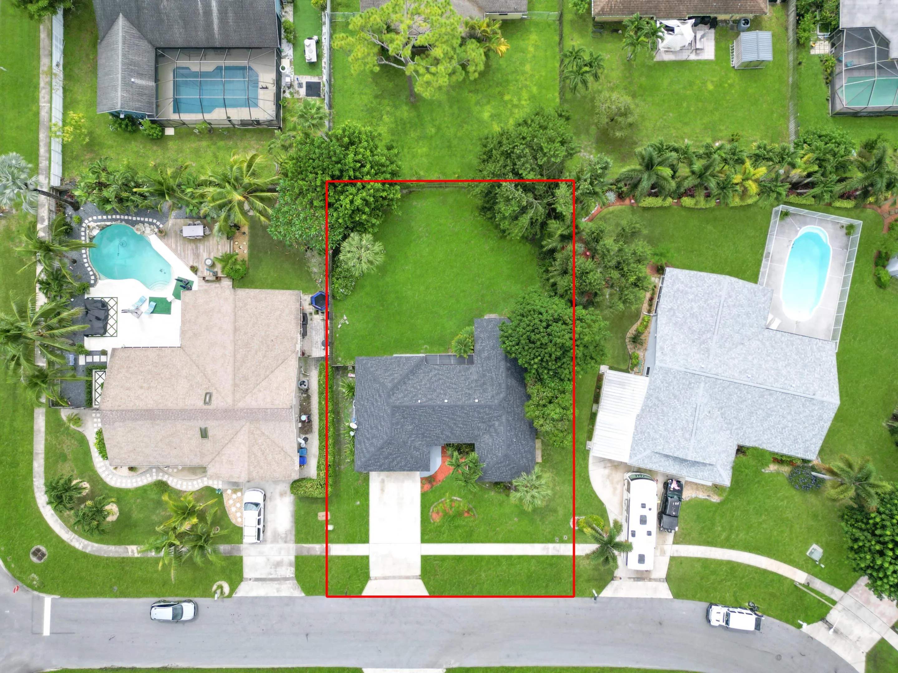 Single-story residence with a gray shingle roof, concrete driveway, and a large grassy yard