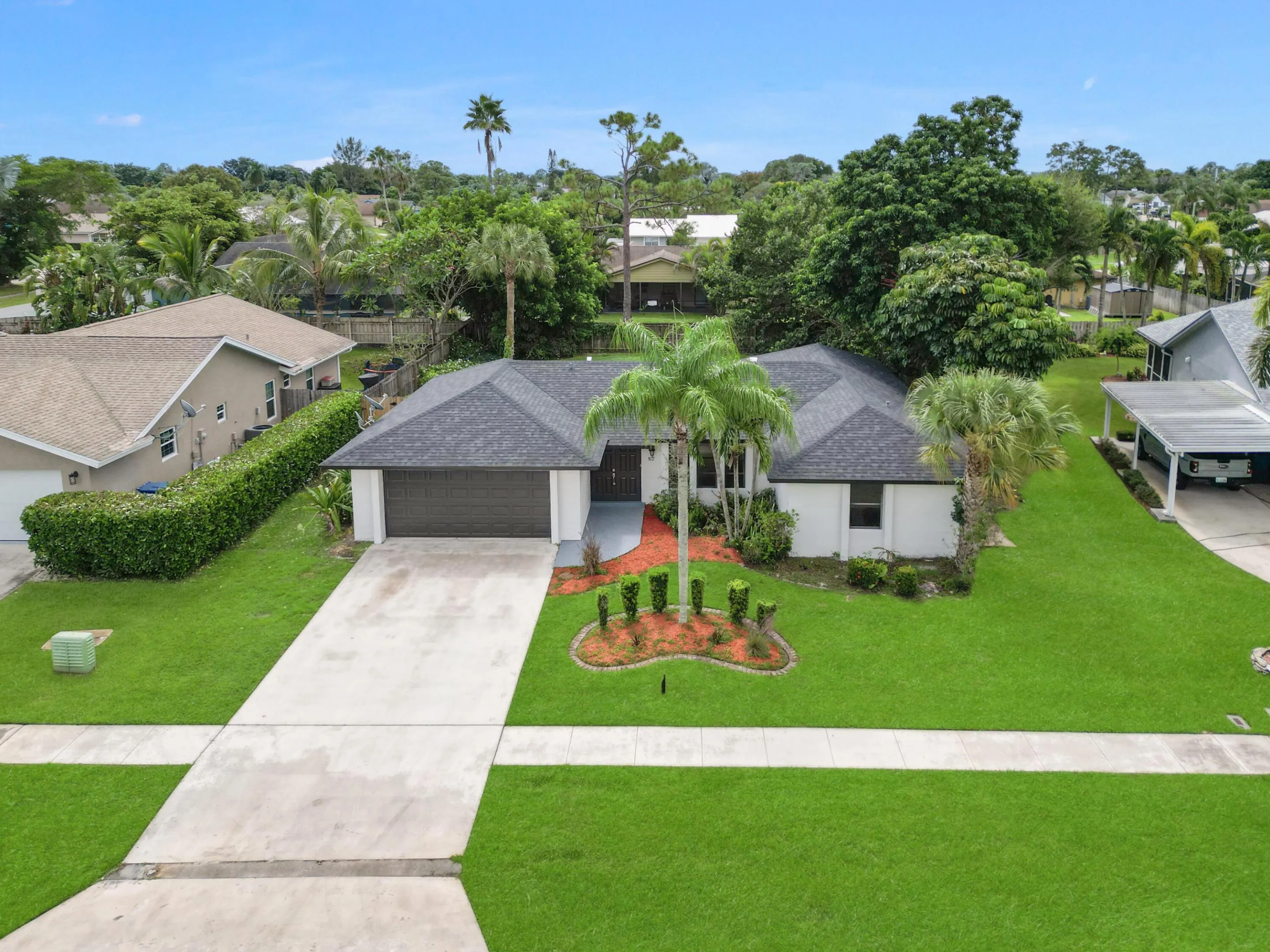 Single-story residence featuring a dark shingle roof, attached garage, and a concrete driveway