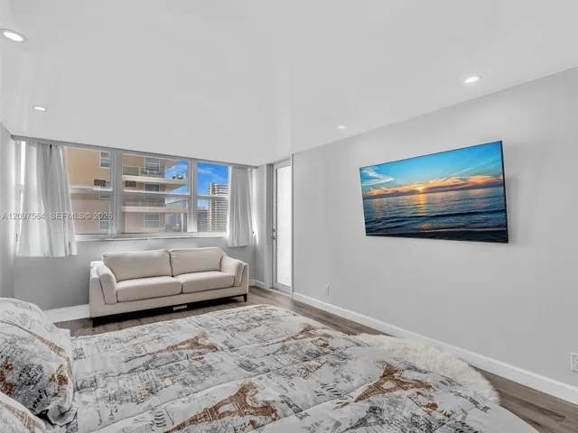 Interior space featuring wood-finish flooring, recessed lighting, expansive multi-pane windows, and a glass-panel exterior door
