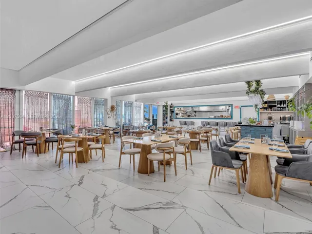 Large-format tile flooring with veining, recessed cove lighting, and floor-to-ceiling windows