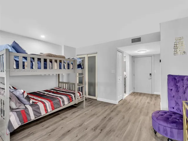 Wood-finish flooring, frosted glass-panel closet doors, and recessed ceiling lighting