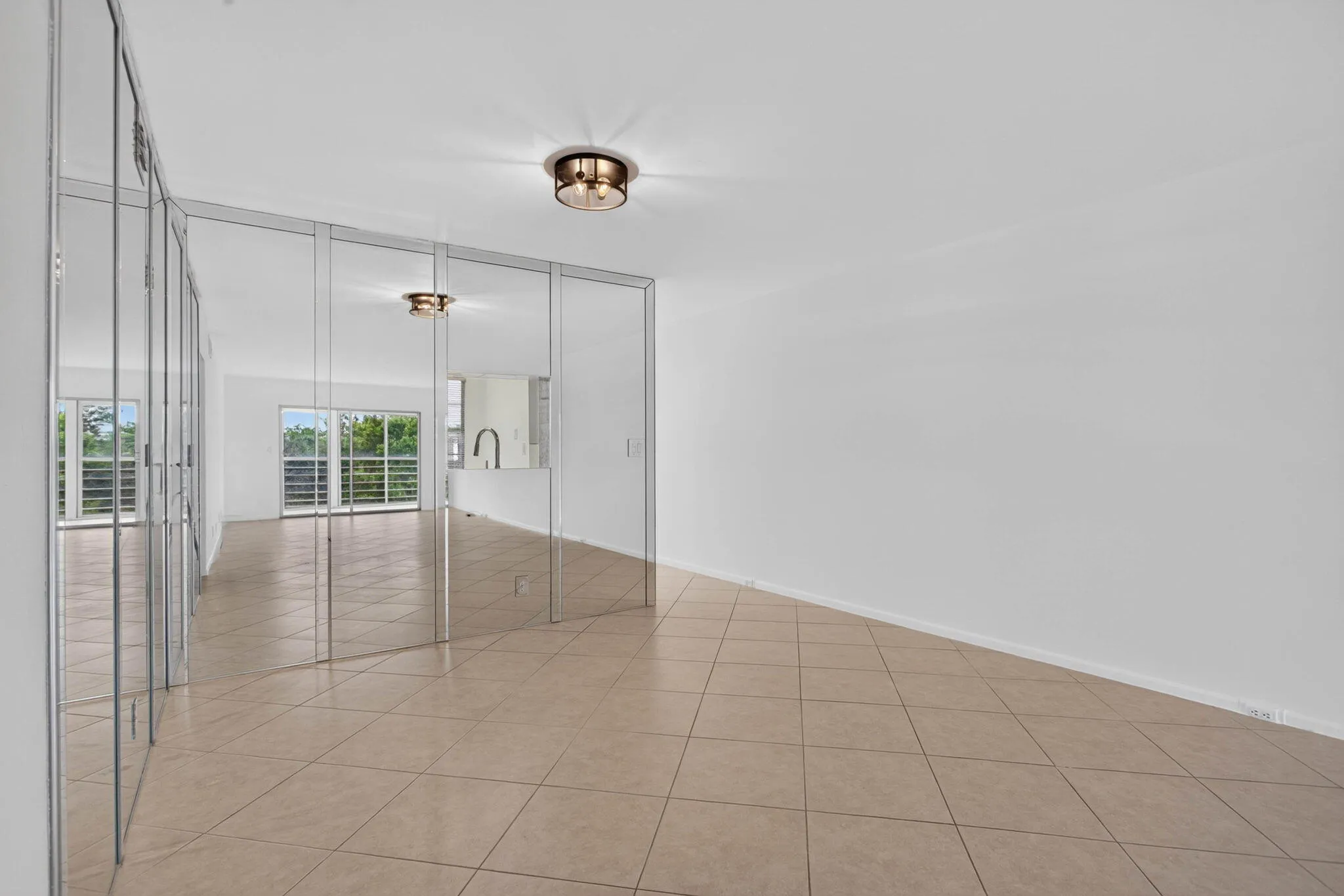 Tile flooring throughout, mirrored wall panels, and a flush mount ceiling light fixture