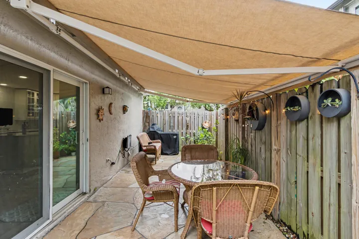 Retractable shade awning and patio misters along the fence to keep cool