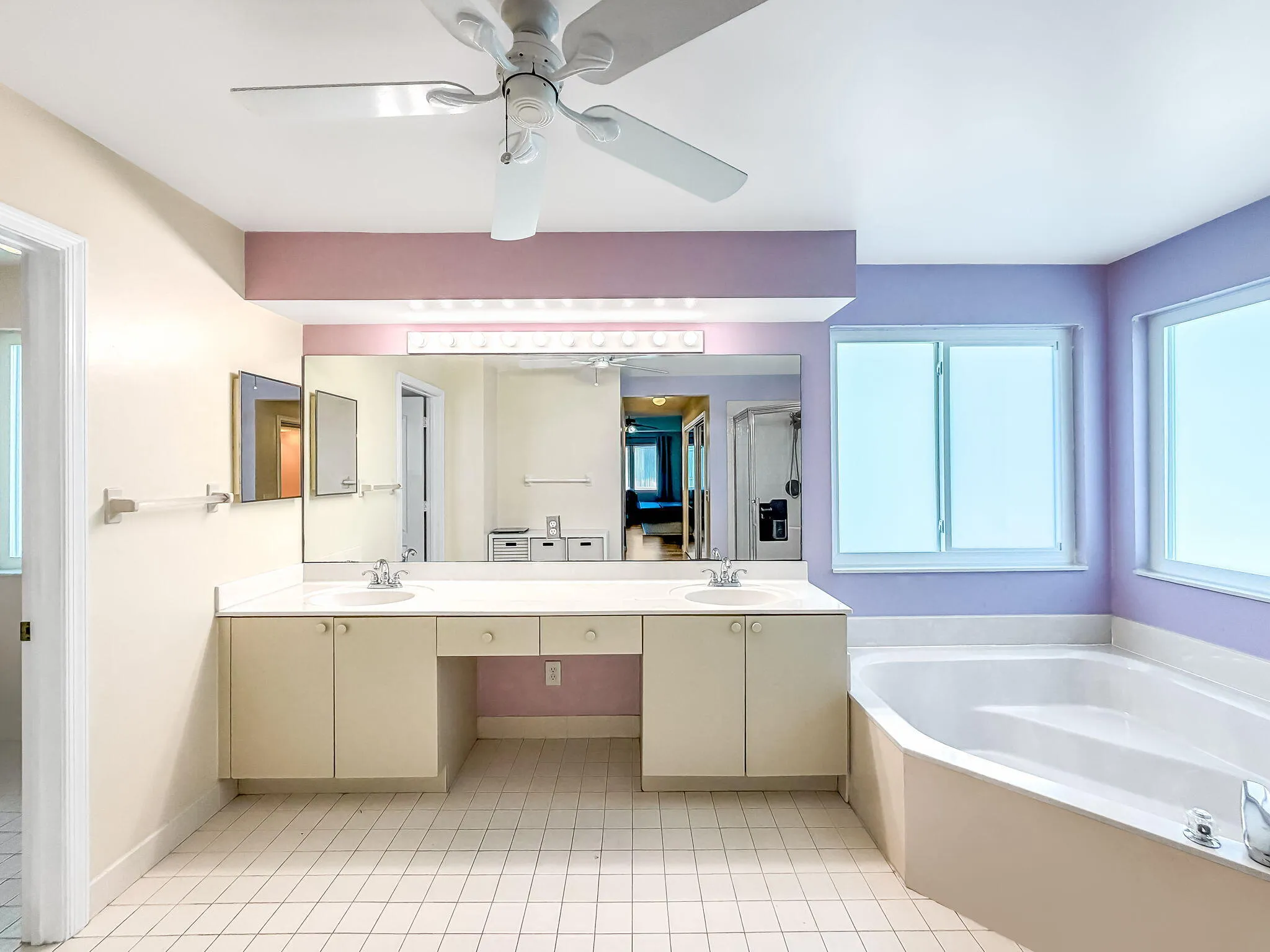 Dual vanity with integrated sinks, built-in cabinetry, and a dedicated makeup area
