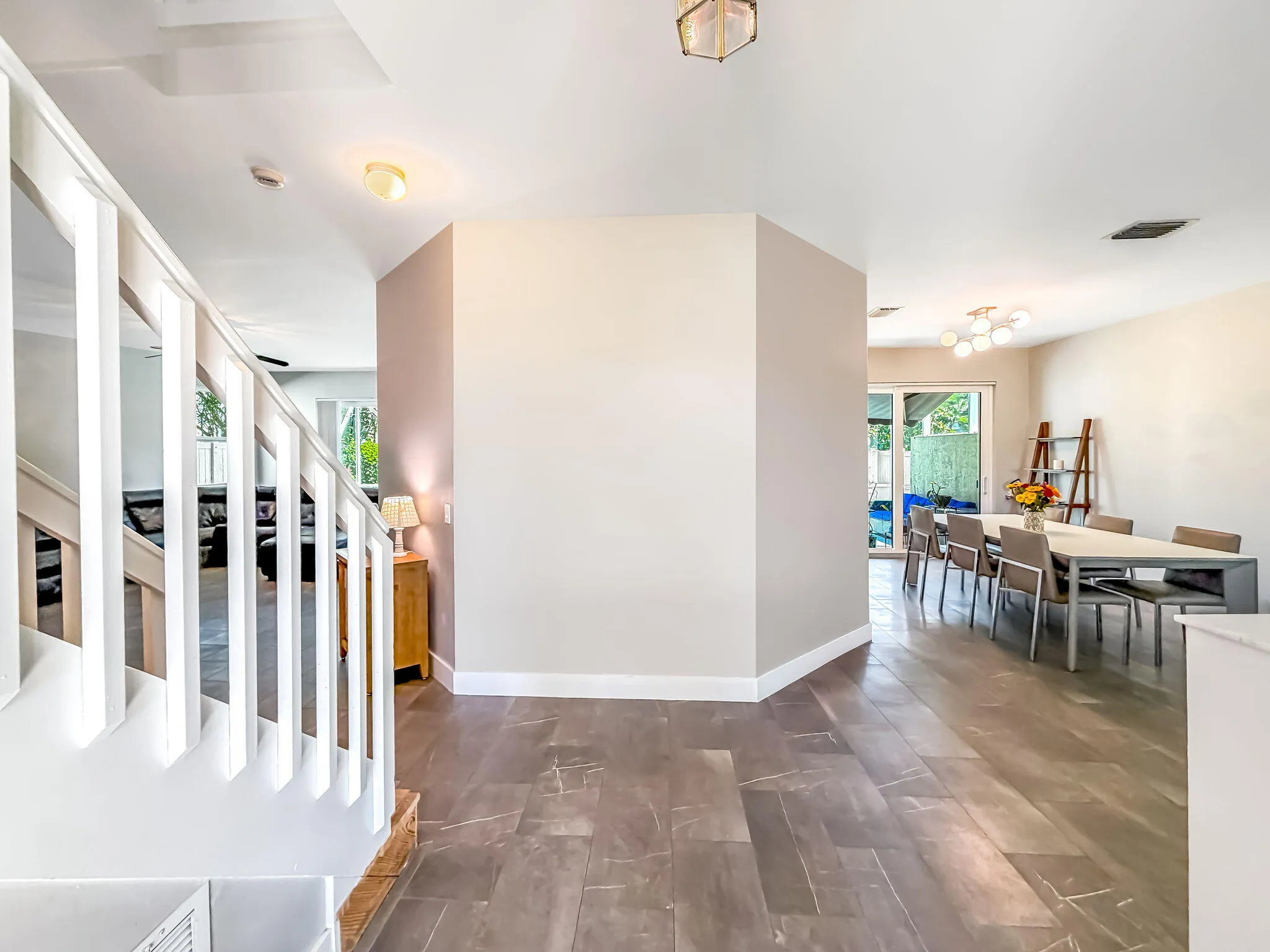 Open floor plan featuring wood-finish flooring, a contemporary staircase, and a dining area with a sliding glass door