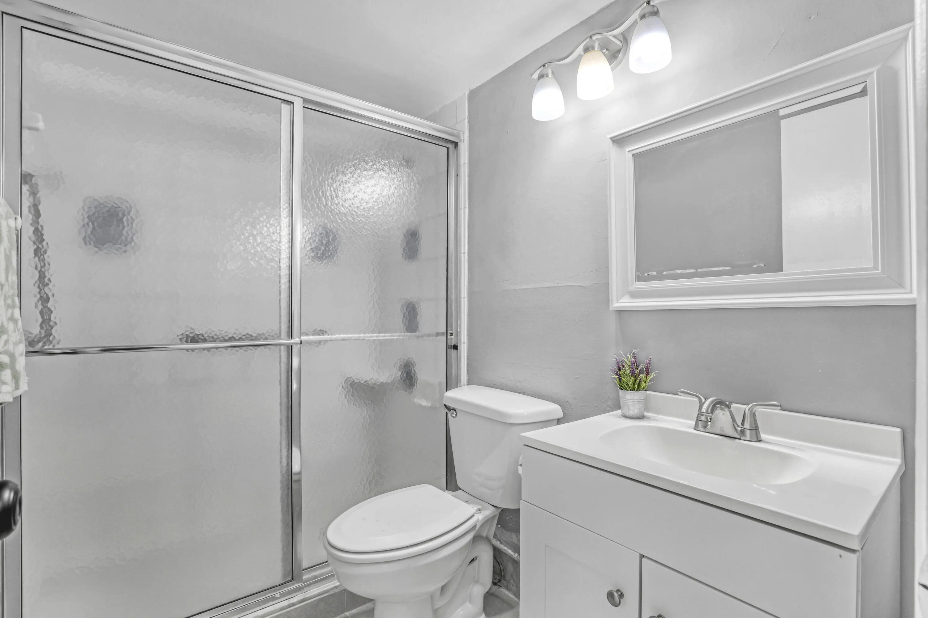 A clean, functional bathroom with a full shower and convenient vanity storage