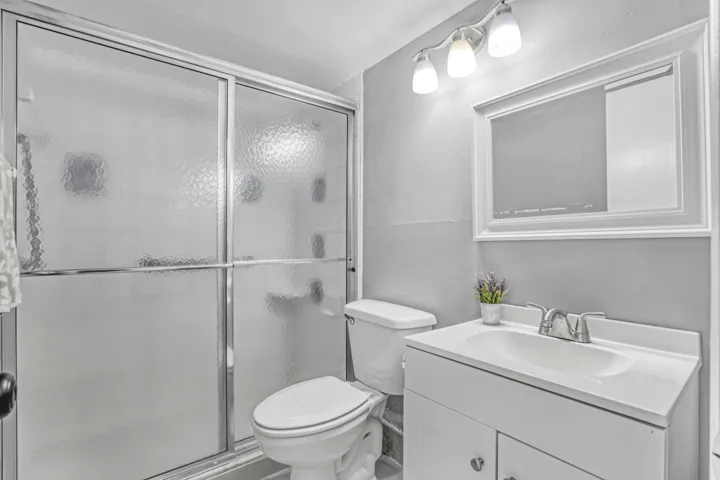 A clean, functional bathroom with a full shower and convenient vanity storage