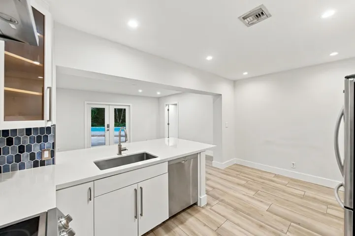 Kitchen island with an undermount sink, quartz countertop, and stainless steel dishwasher