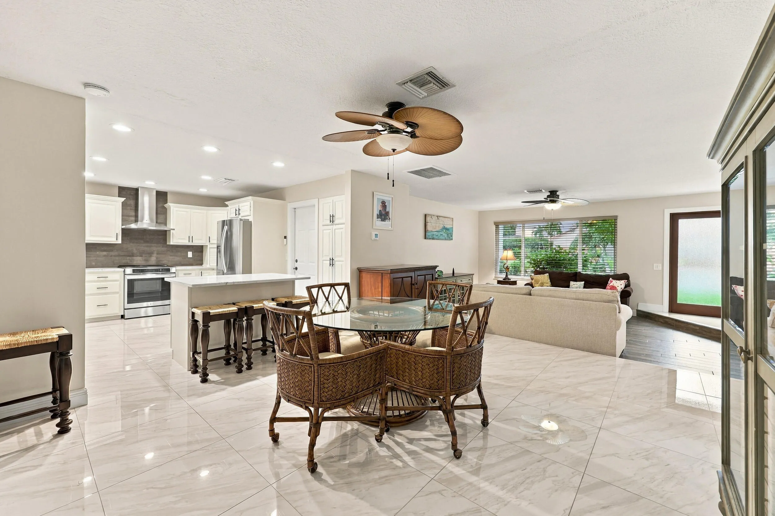 The dining space and eat-in kitchen are highlighted by new floors and a beautifully updated kitchen with quartz countertops and stainless steel appliances. Views of the resort-style pool can be seen from all areas of the house.