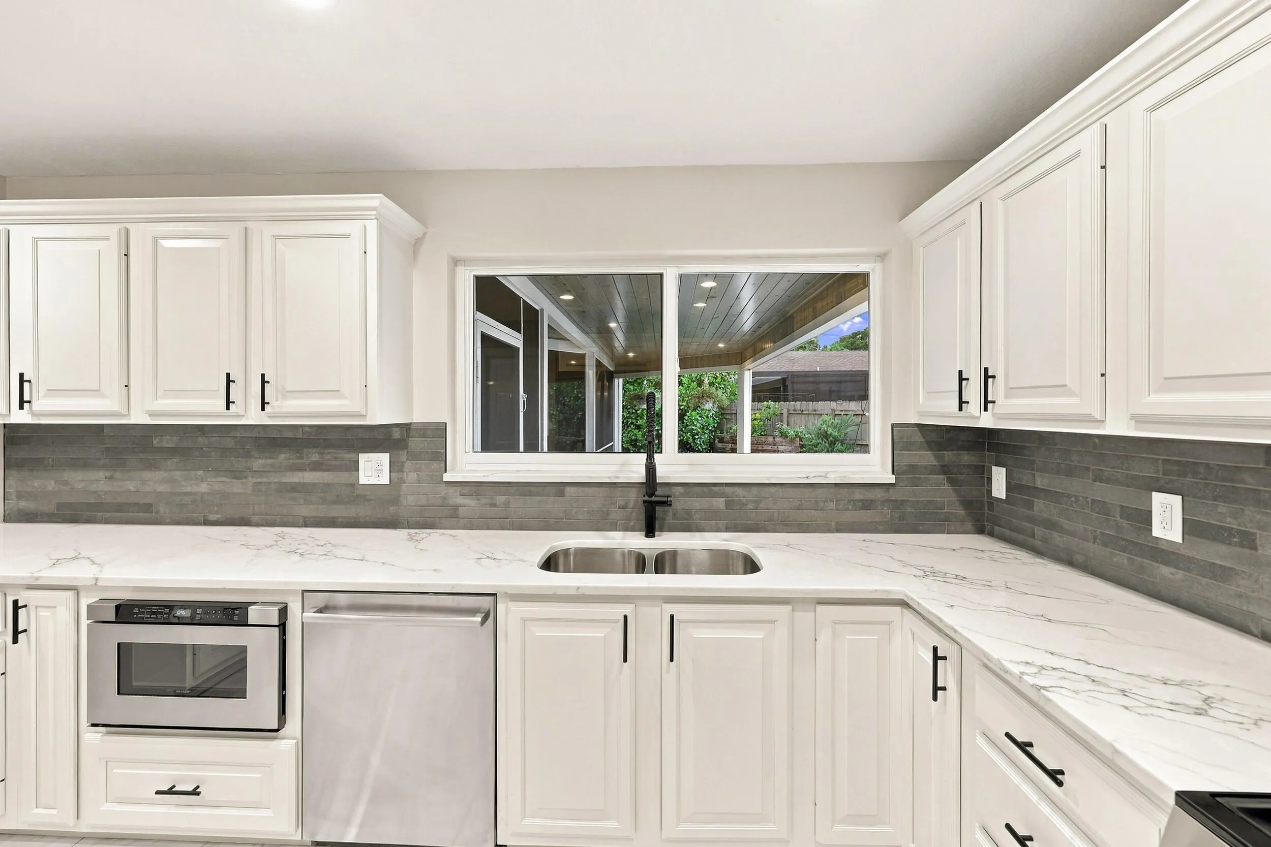 From the kitchen sink, you can admire the resort-style pool, spacious backyard, and 900-square-foot covered and screened-in patio.