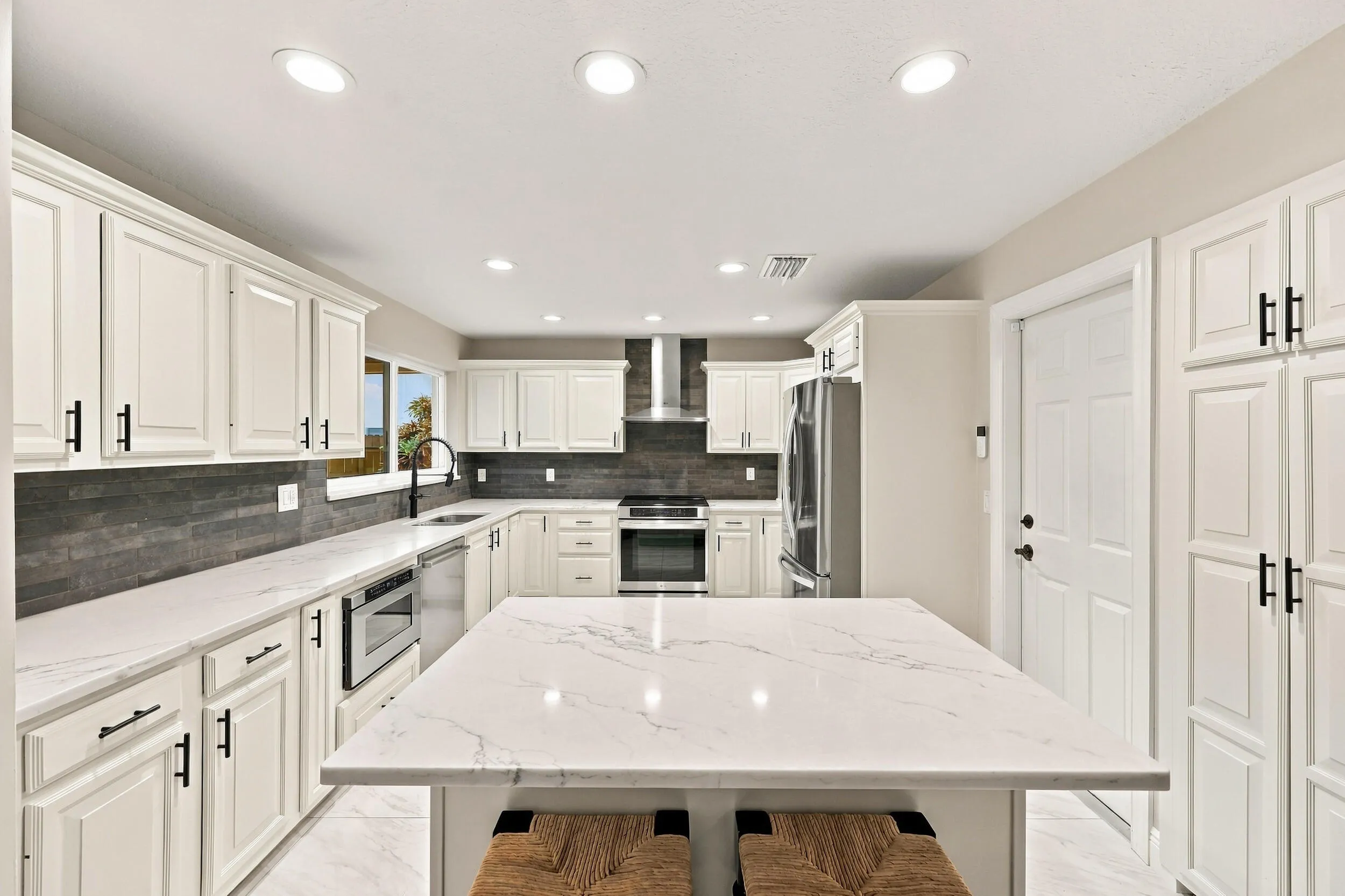 The impeccably upgraded kitchen offers white cabinetry, quartz countertops, stainless steel appliances, and a beautiful charcoal backsplash. There is tons of storage and counter space for even the most discerning chef.