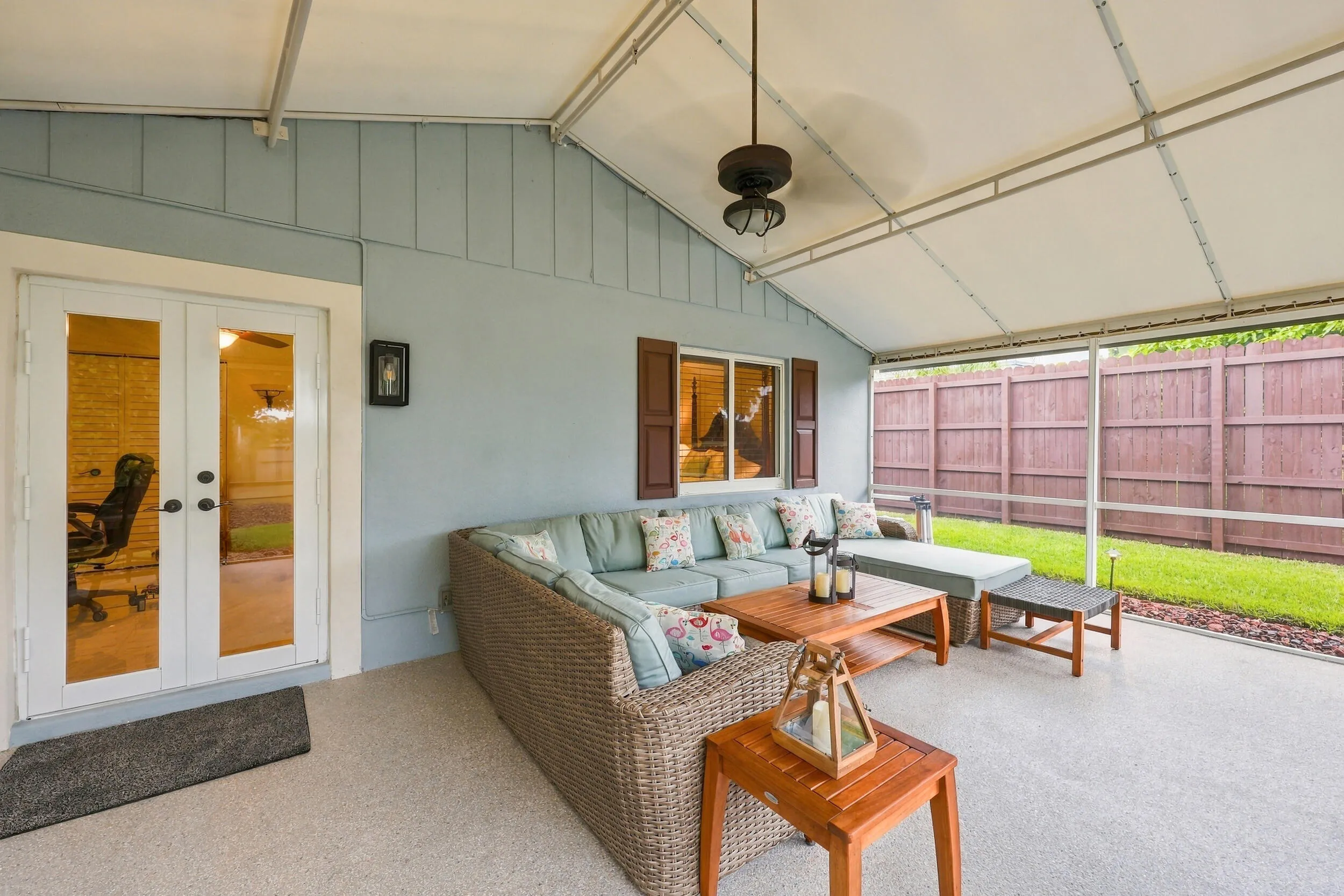 A living room outside is highlighted by vaulted ceilings, a privacy fence, views of Lakeview Golf Course, and a versatile area to entertain.