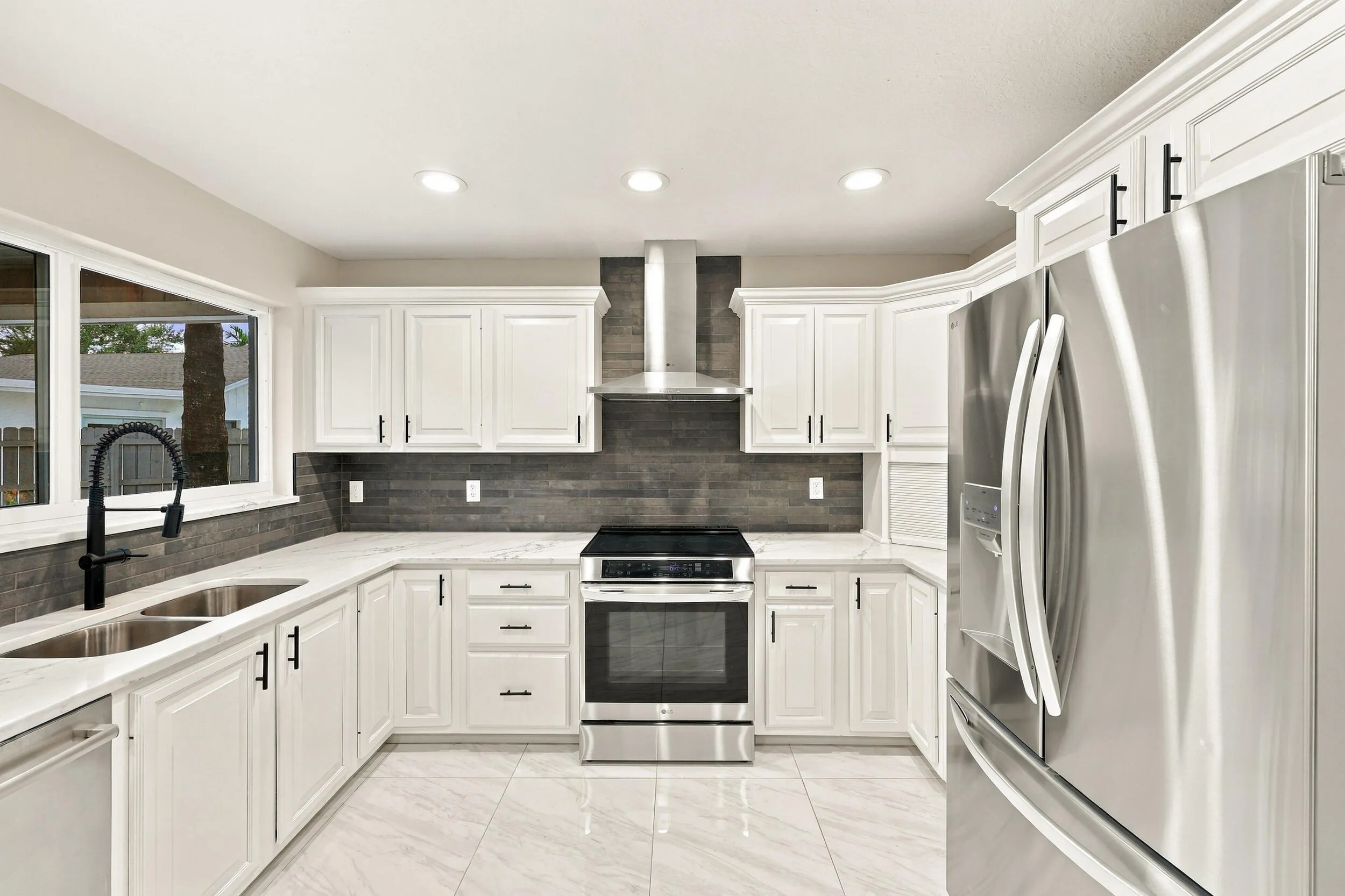 The impeccably upgraded kitchen offers white cabinetry, quartz countertops, stainless steel appliances, and a beautiful charcoal backsplash. There is tons of storage and counter space for even the most discerning chef.