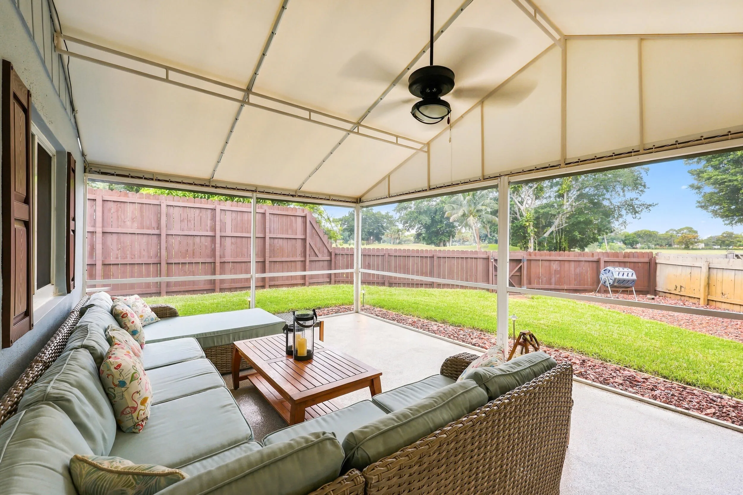 A living room outside is highlighted by vaulted ceilings, a privacy fence, views of Lakeview Golf Course, and a versatile area to entertain.