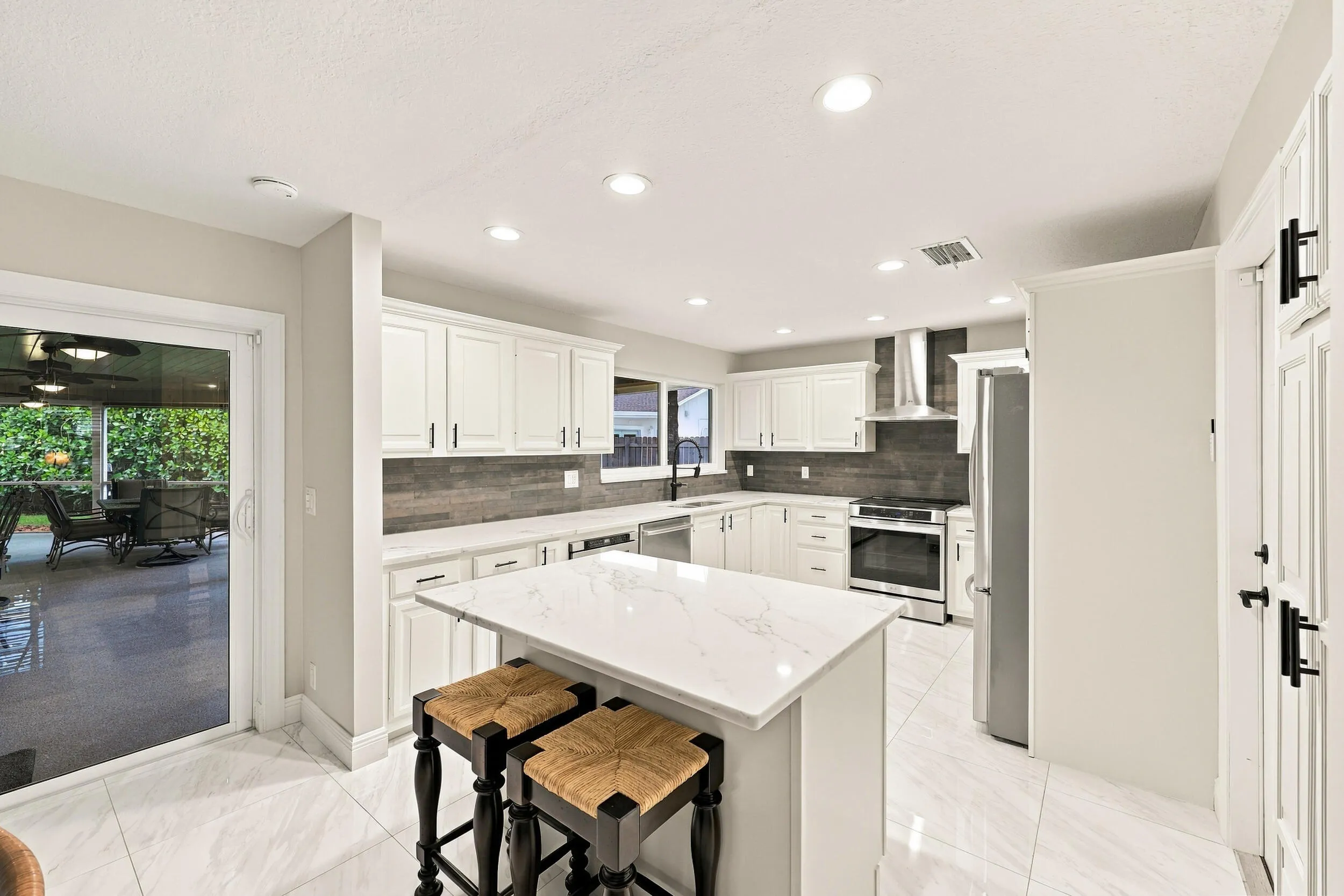 The dining space and eat-in kitchen are highlighted by new floors and a beautifully updated kitchen with quartz countertops and stainless steel appliances. Views of the resort-style pool can be seen from all areas of the house.