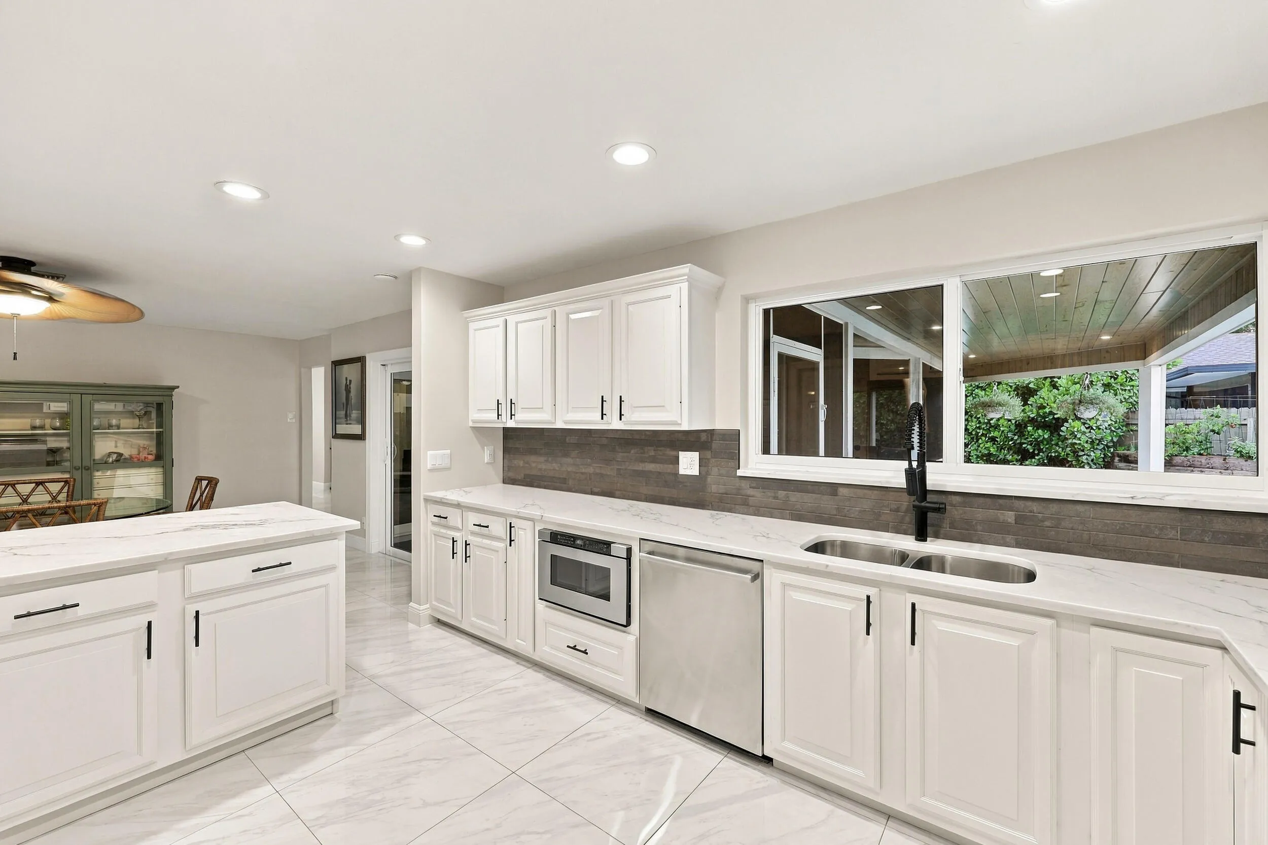 From the kitchen sink, you can admire the resort-style pool, spacious backyard, and 900-square-foot covered and screened-in patio.