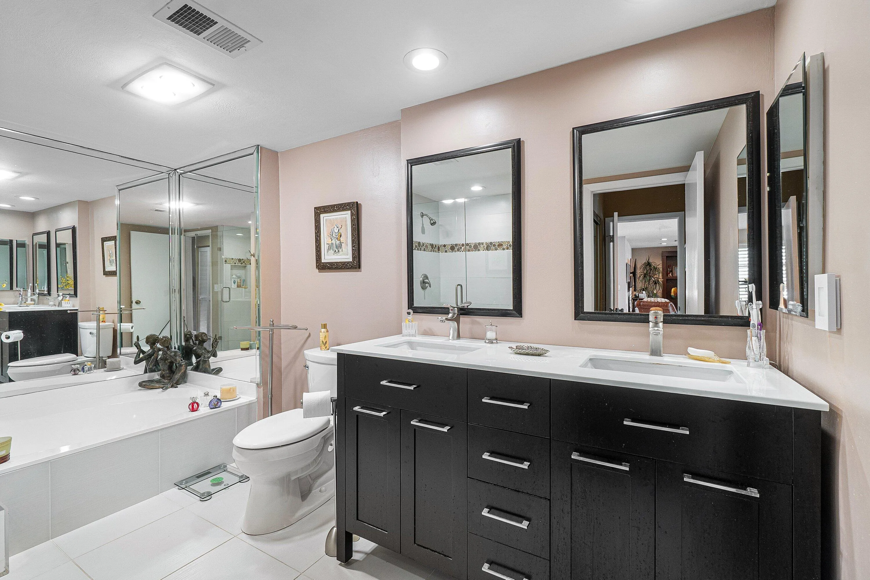 Dual vanity with undermount sinks, white countertop, and dark wood-finish cabinetry
