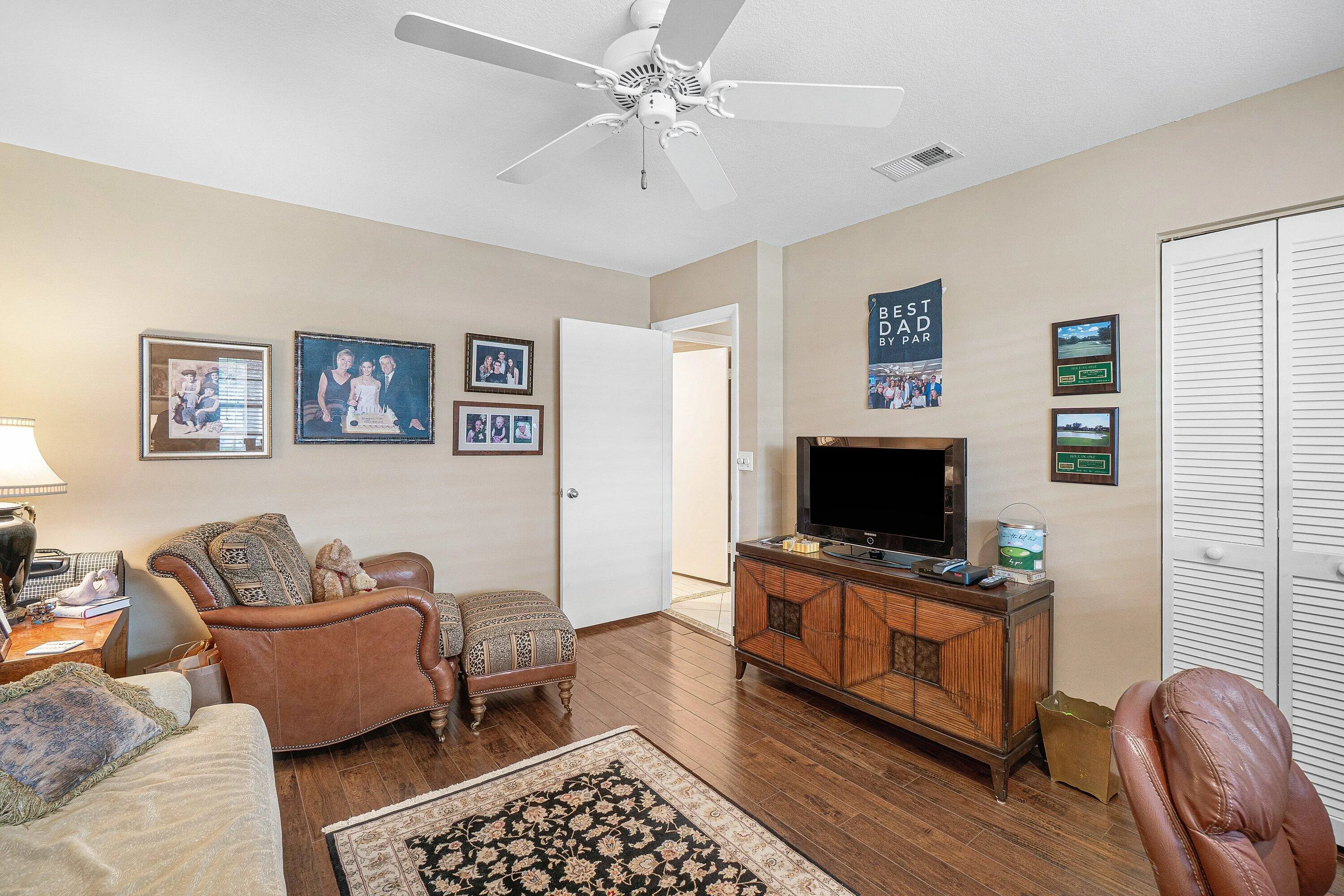 Wood-finish flooring, ceiling fan, and louvered bifold doors