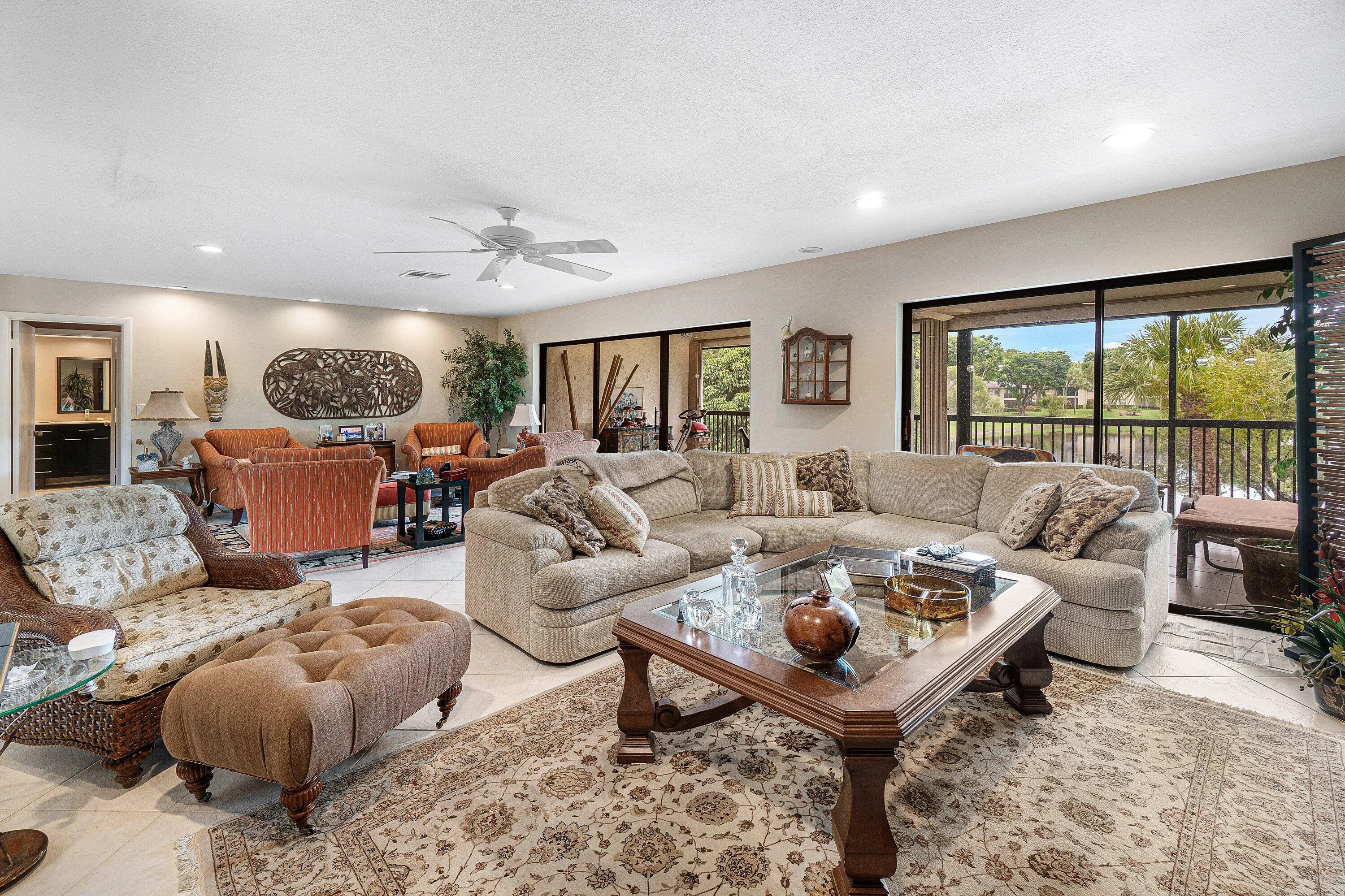 Spacious living area featuring tile flooring, ceiling fan, recessed lighting, and expansive sliding glass doors