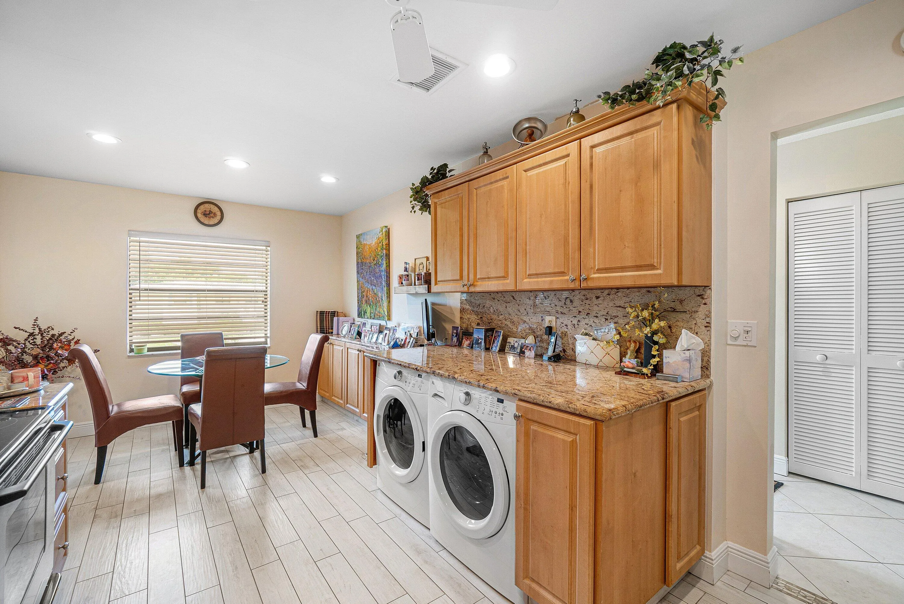 Wood-finish flooring, recessed lighting, wood cabinetry, granite-finish countertop, and a tiled backsplash