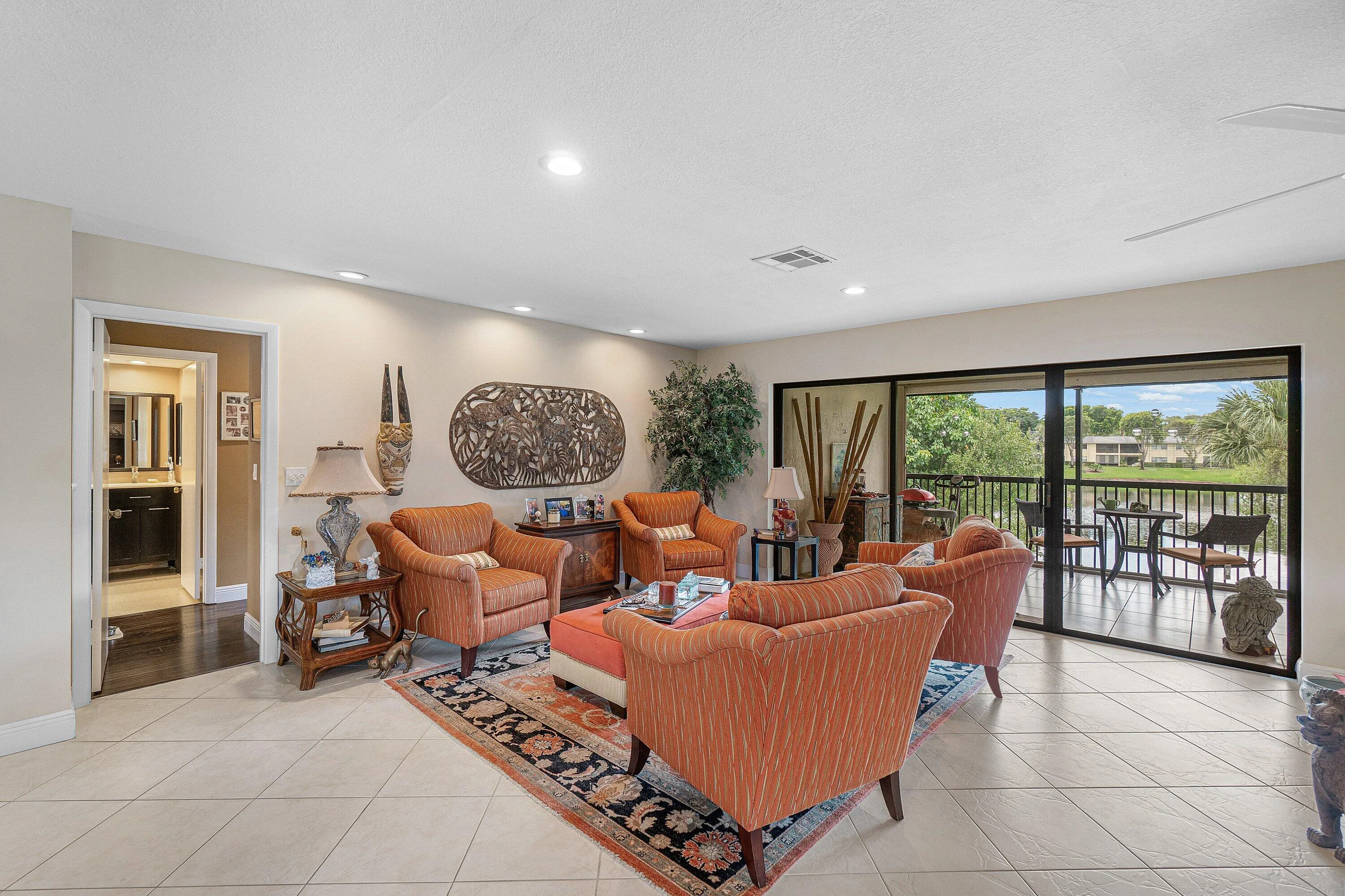 Recessed lighting illuminates the living space, featuring neutral wall tones and tile flooring