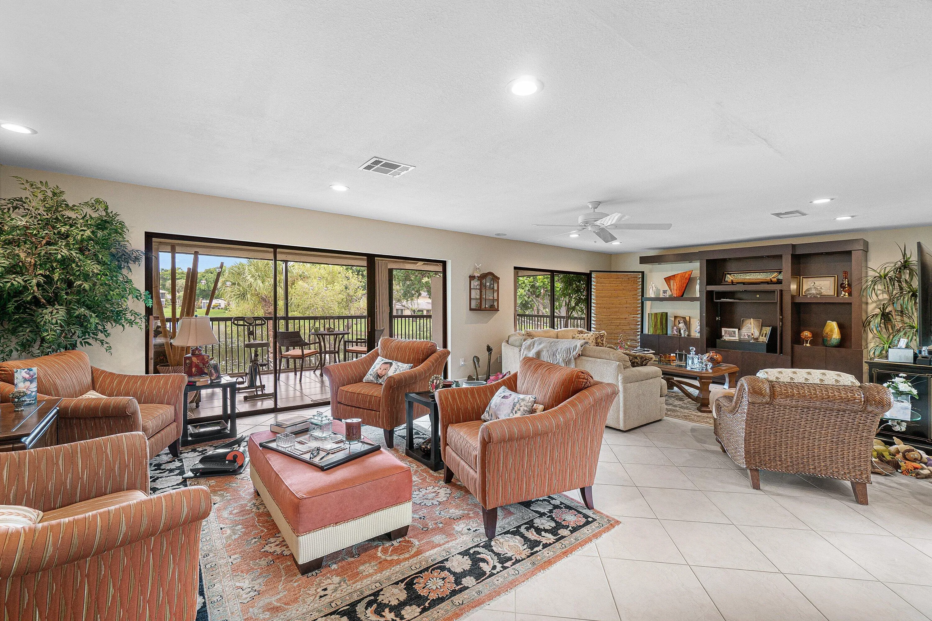 Living area featuring tile flooring, recessed lighting, a ceiling fan, and built-in shelving