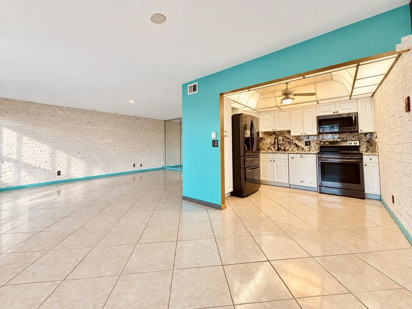 Dining Area to Living Area With View of Kitchen. Neutral Tile Flooring Flows Throughout