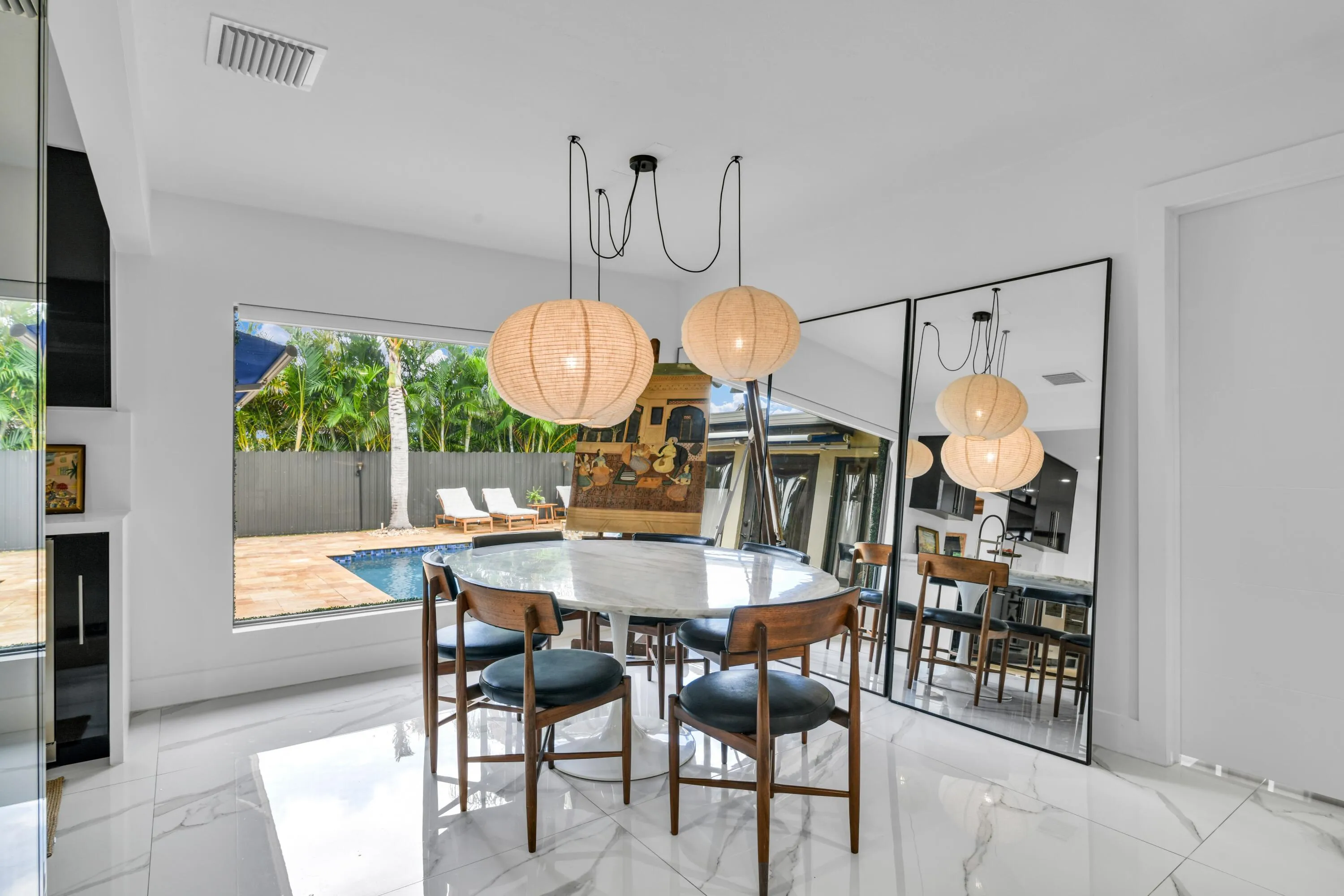 Polished tile flooring, custom built-in cabinetry, and a large picture window overlooking the pool