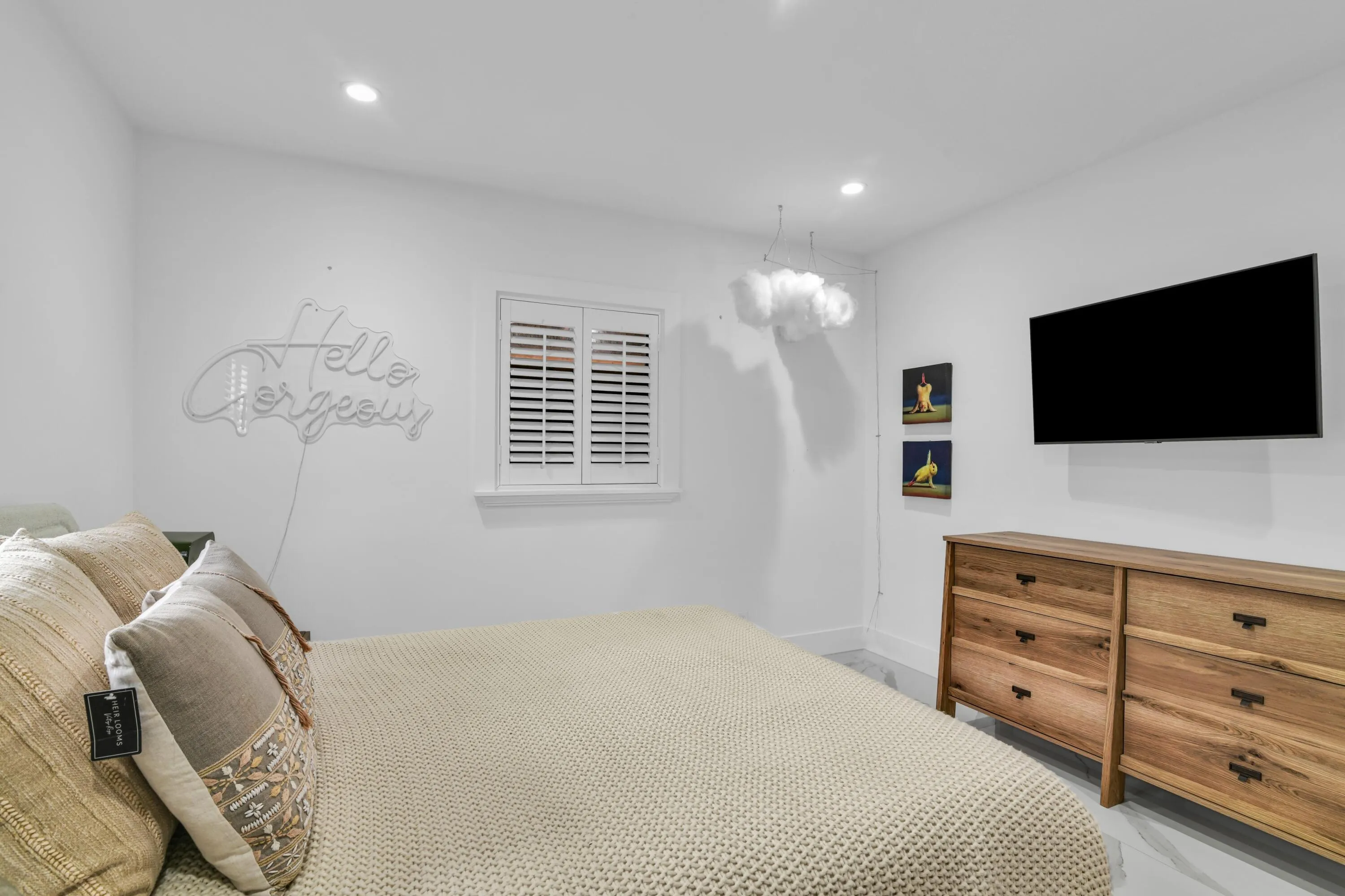 Recessed ceiling lighting, white plantation shutters, and a wall-mounted flat-screen television