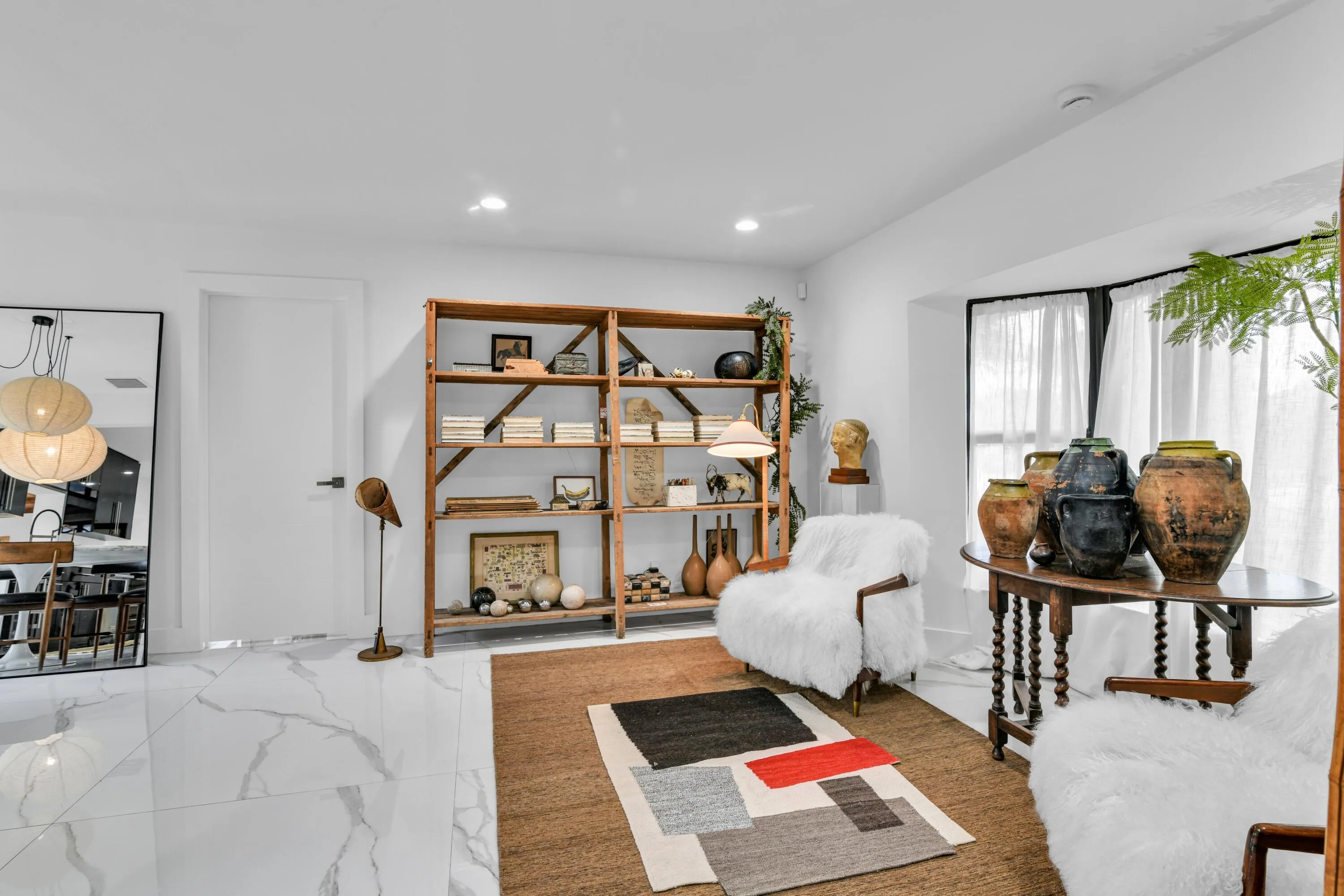 White walls with recessed lighting, large bay window with dark trim, white tile flooring, and built-in wooden shelving