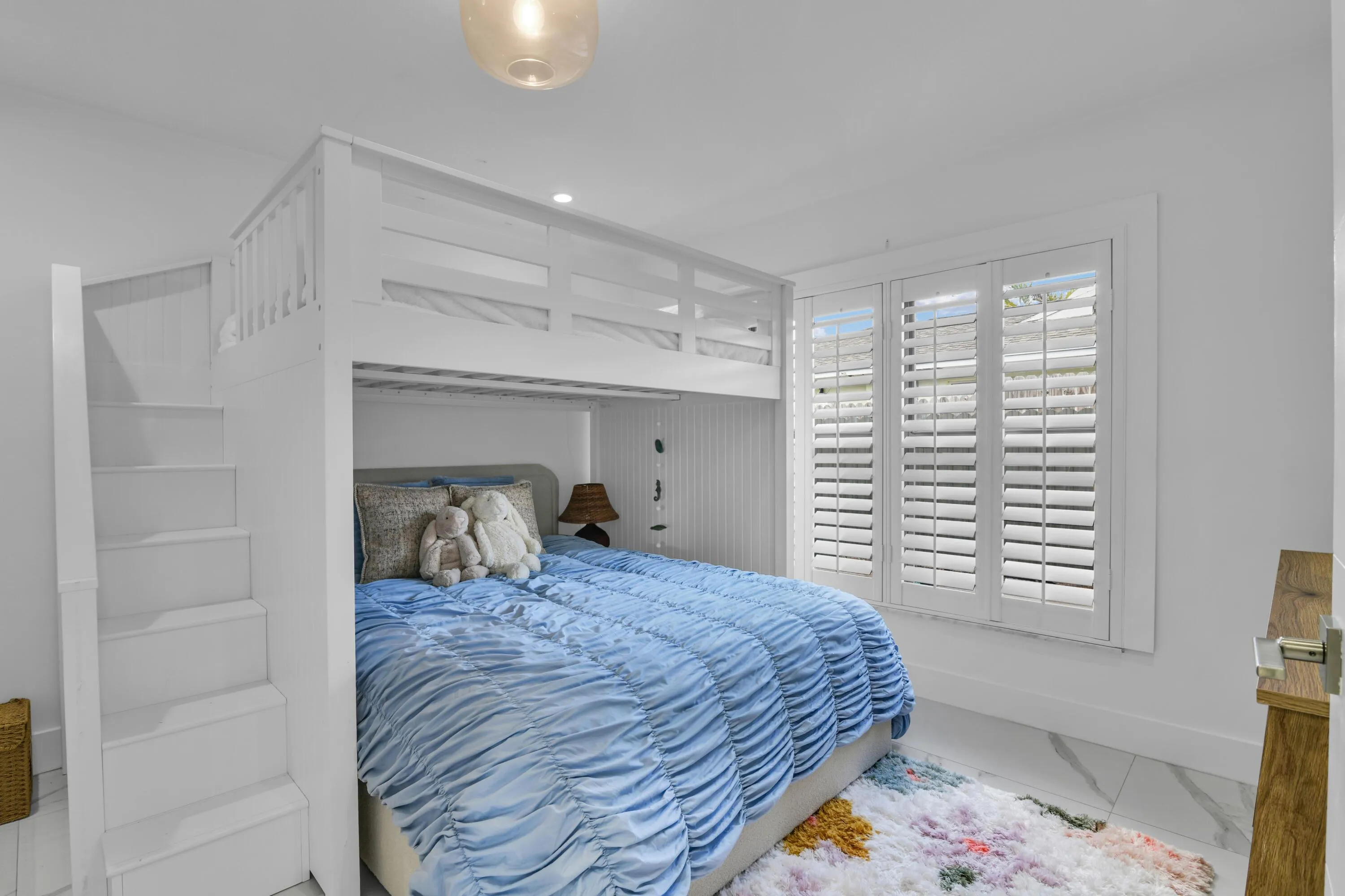 Built-in bunk bed system featuring integrated stairs and a top bunk with railing