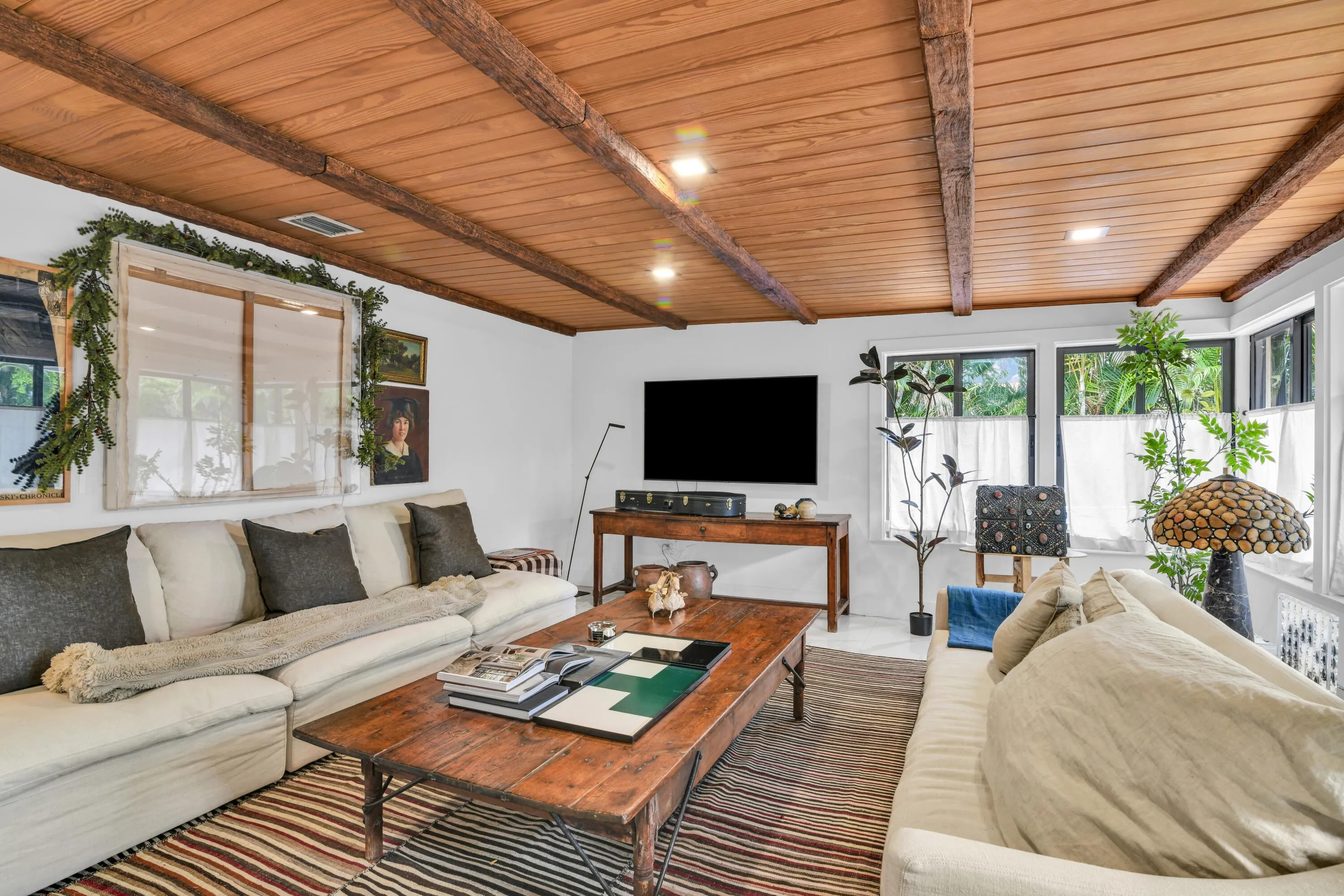 Wood-planked ceiling with exposed beams, recessed lighting, and multiple large windows with natural light