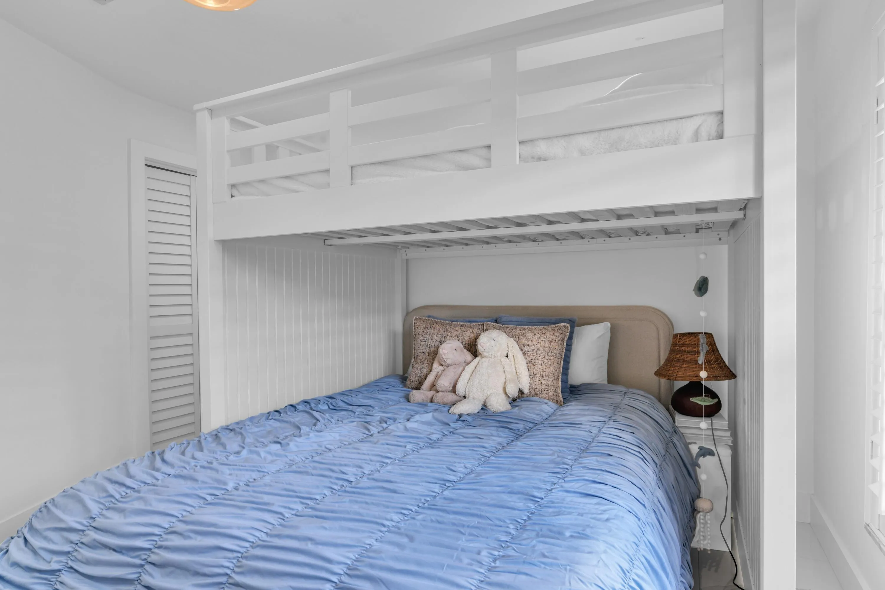 Built-in bunk bed system featuring a lower bed with upholstered headboard and an upper bed with safety rails