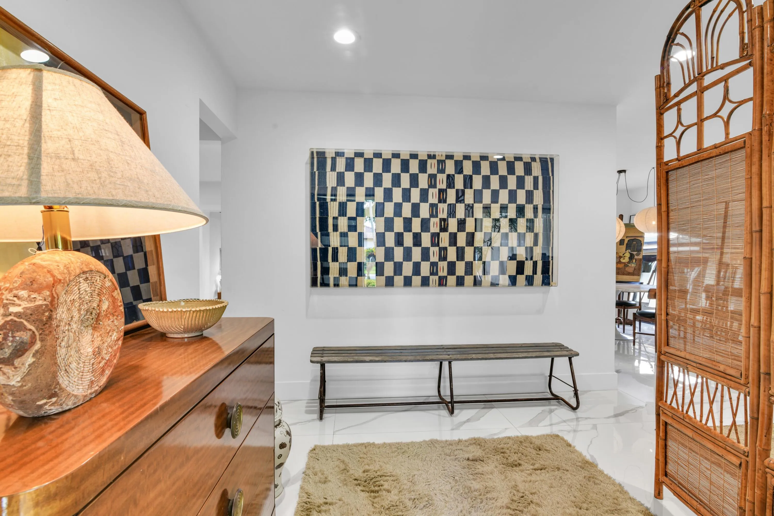 White walls with recessed lighting, marble-finish flooring, and a bamboo privacy screen