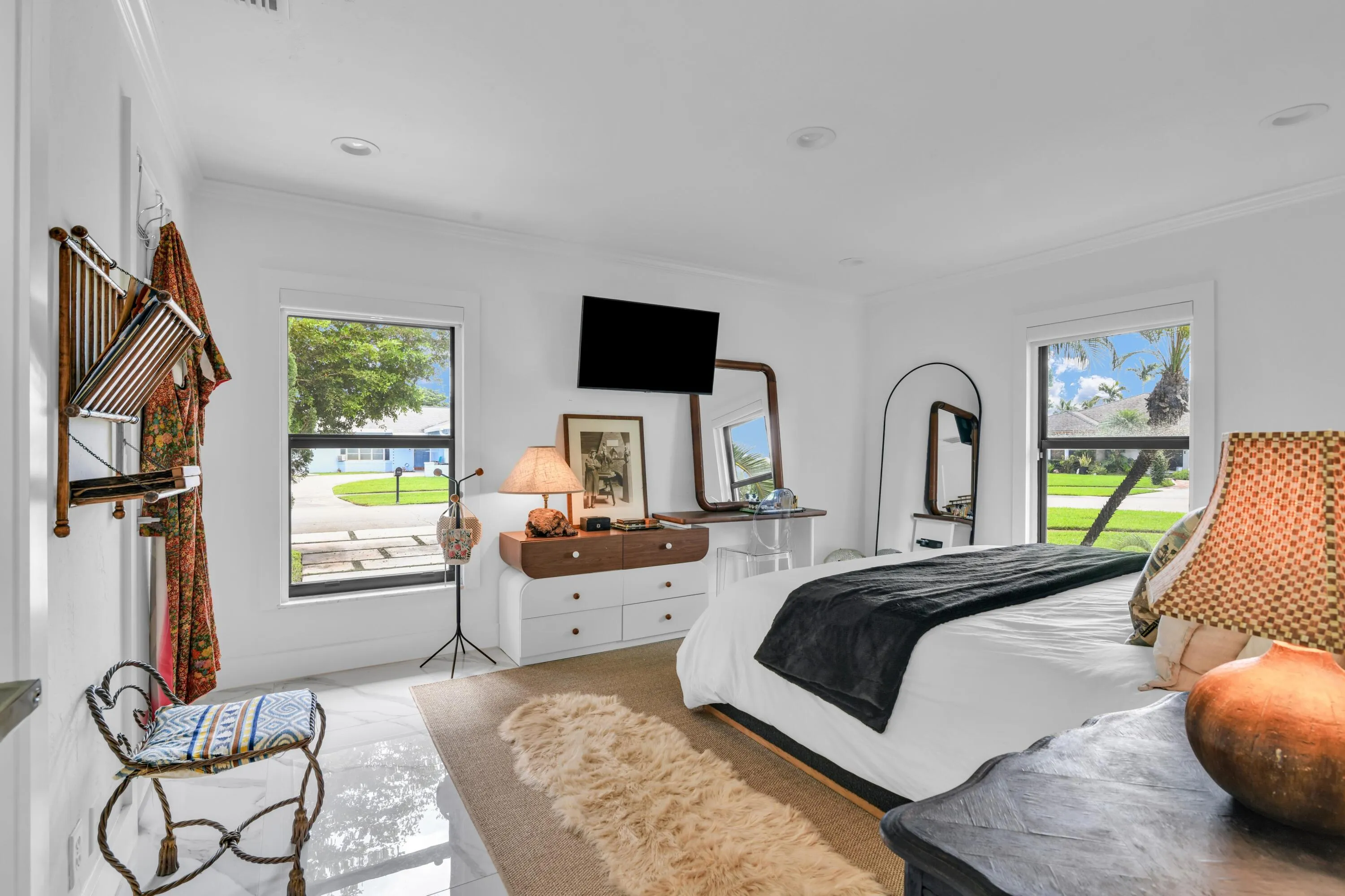Recessed lighting, large windows with black framing, crown molding, and white tile flooring