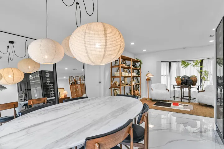 Polished white flooring, bay window, built-in shelving, and contemporary pendant lighting fixtures