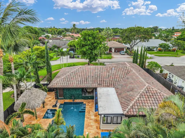 Terra cotta tile roof with a central swimming pool, integrated spa, and adjacent tiki hut