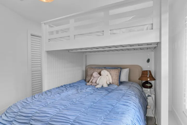 Built-in bunk bed system featuring a lower bed with upholstered headboard and an upper bed with safety rails