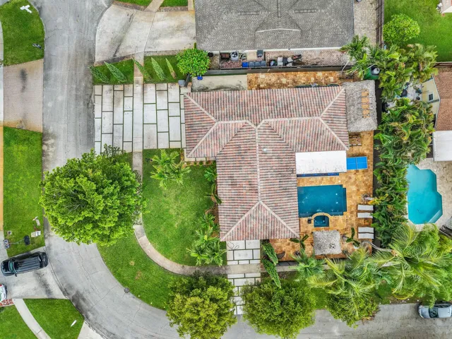 Tile roof, geometric paver driveway, manicured lawn, swimming pool, and spa