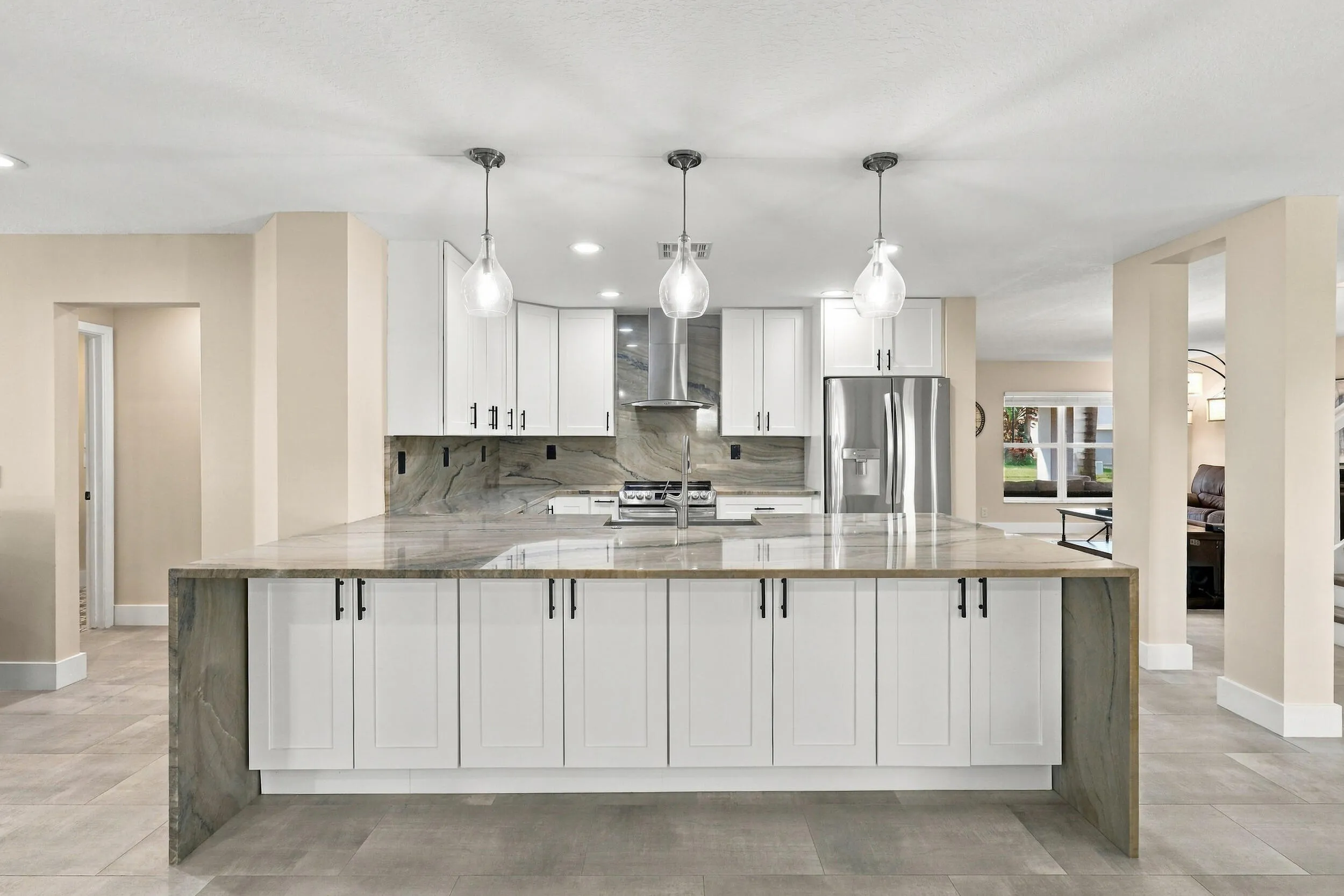 The enormous kitchen peninsula provides tons of additional storage, a great place to gather and eat within the kitchen, and is highlighted by a magnificent piece of natural quartzite stone.
