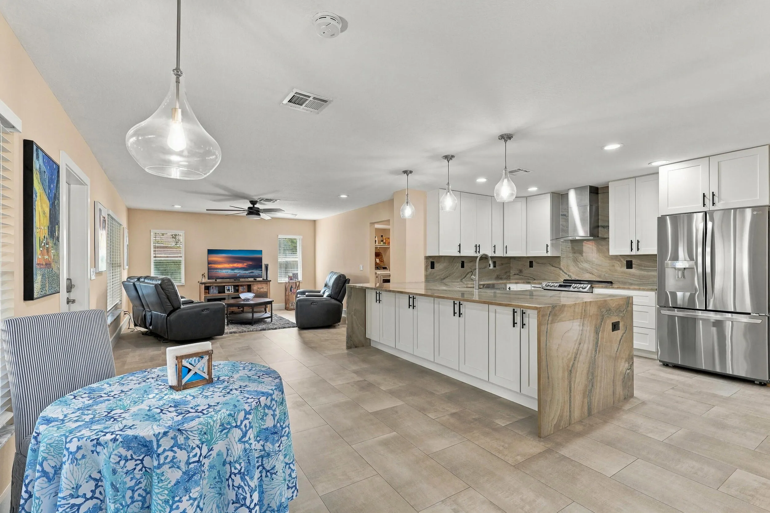 The heart of the home is the exquisite renovated kitchen, featuring white Shaker style cabinetry, stunning quartzite countertops and backsplash, stainless steel appliances, designer lighting, abundant storage, and an oversized island that creates an impressive centerpiece for everyday living and entertaining. The open layout flows effortlessly into the main living areas and breakfast nook, while a separate dining space provides plenty of room for gatherings.