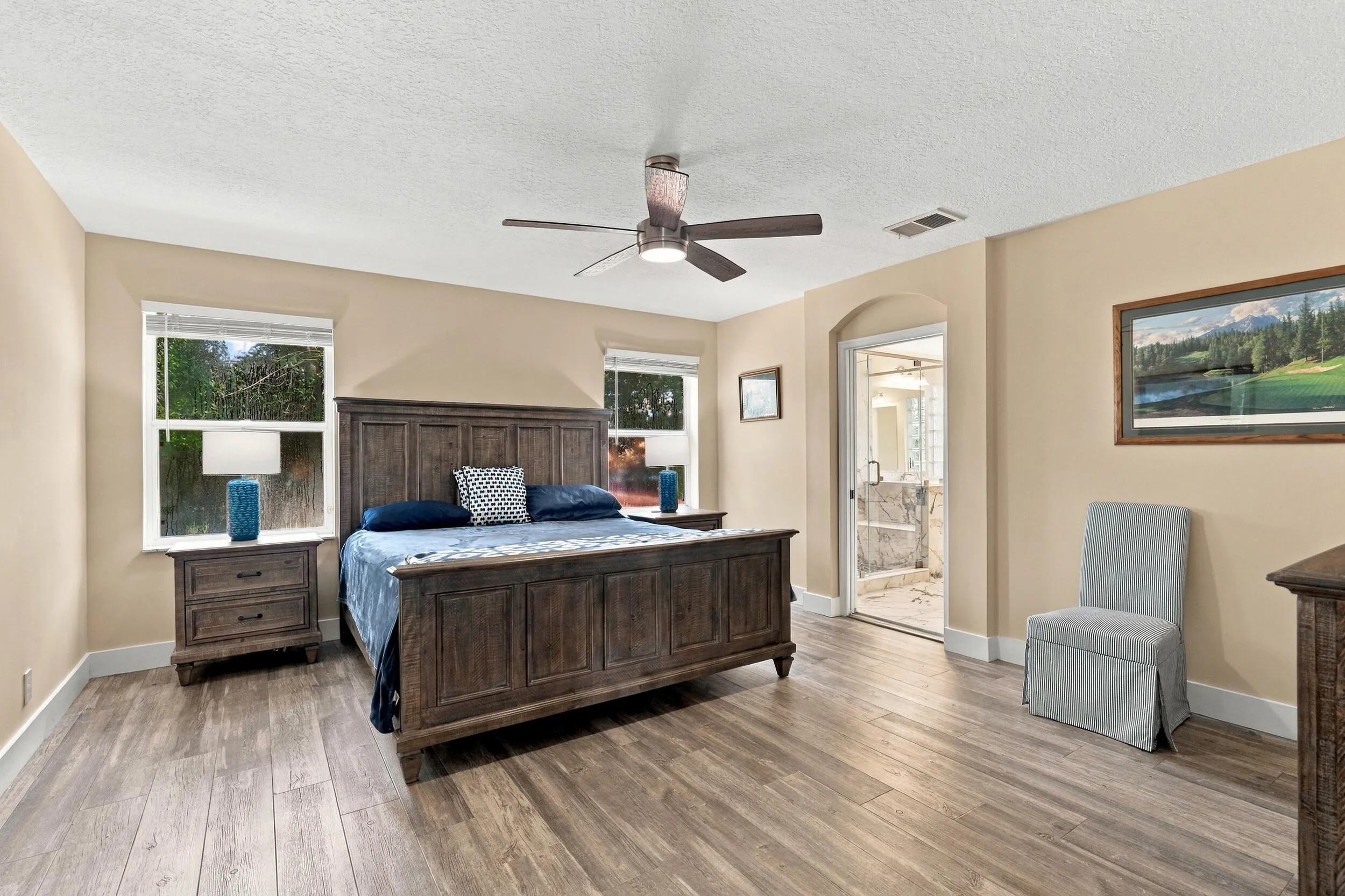 The primary suite is enormous! It offers lots of natural light, a spa-like ensuite bathroom with a marble shower, frameless glass, as well as a walk-in closet and soaking tub.