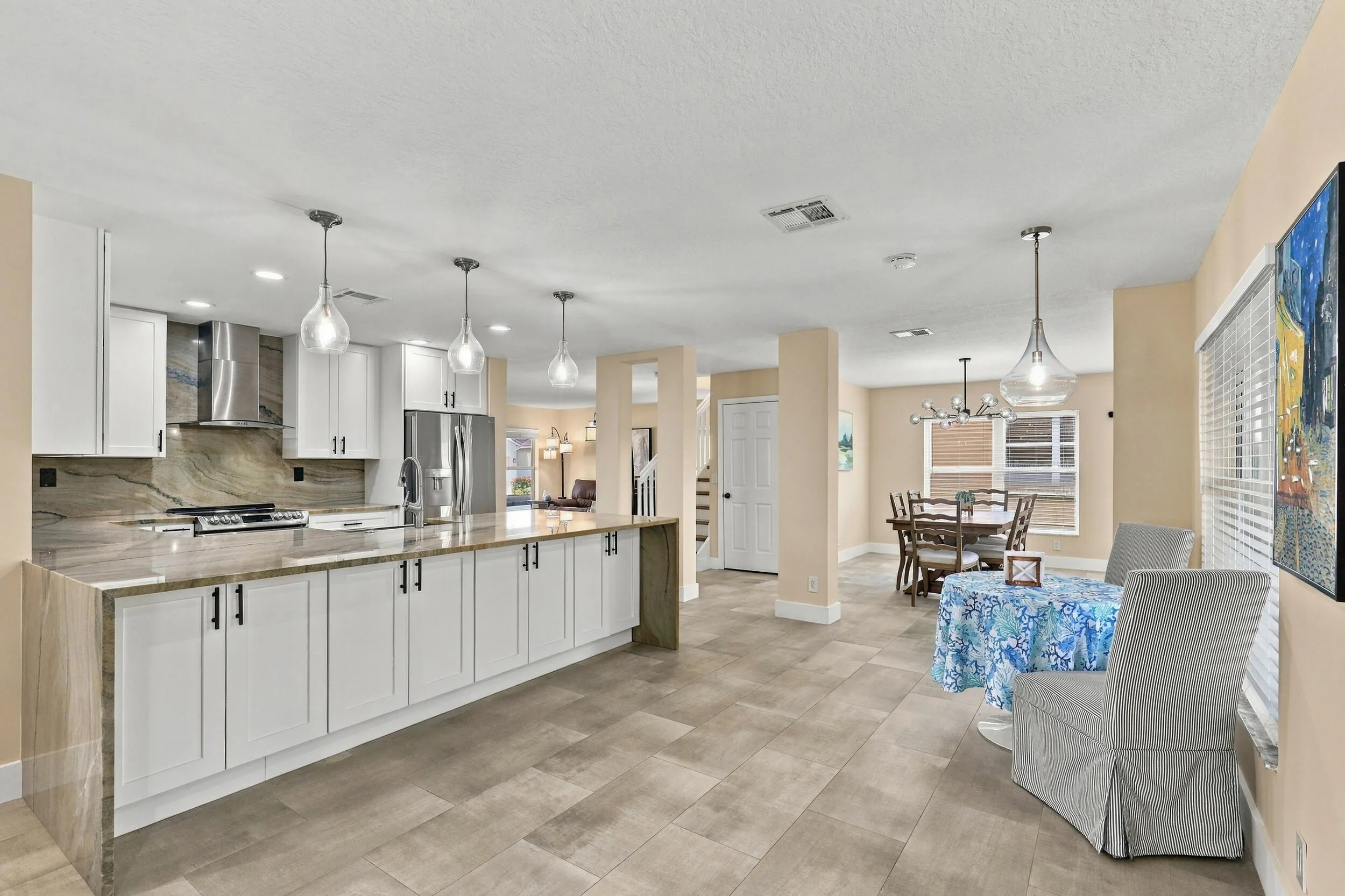 The enormous kitchen peninsula provides tons of additional storage, a great place to gather and eat within the kitchen, and is highlighted by a magnificent piece of natural quartzite stone.